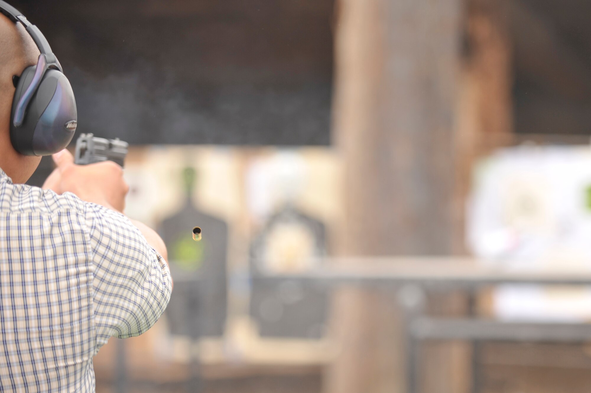 VANDENBERG AIR FORCE BASE, Calif. -- A law enforcement member fires his weapon during the 4th Annual Bowling Pin Shootout at the Rod and Gun Club here Friday, July 22, 2011.  The Office of Special Investigations sponsored the event to help build relationships between different law enforcement agencies.  (U.S. Air Force photo/Staff Sgt. Andrew Satran) 

  
 
 