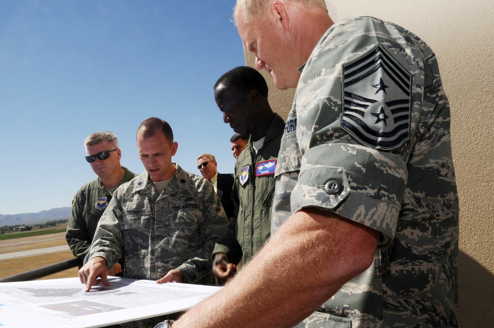 FROM LEFT: Brig. Gen. J.D. Harris Jr., 56th Fighter Wing commader, looks on as Lt. Col. John Thomas, 56th Mission Support Group deputy commander, explains the plans for the construction of a potential solar power plant July 14 to Gen. Edward Rice Jr., Air Education and Training Command commander, and Chief Master Sgt. James Cody, AETC command chief, during a visit to Luke Air Force Base.  (U.S. Air Force photo by Senior Airman Tracie Forte)