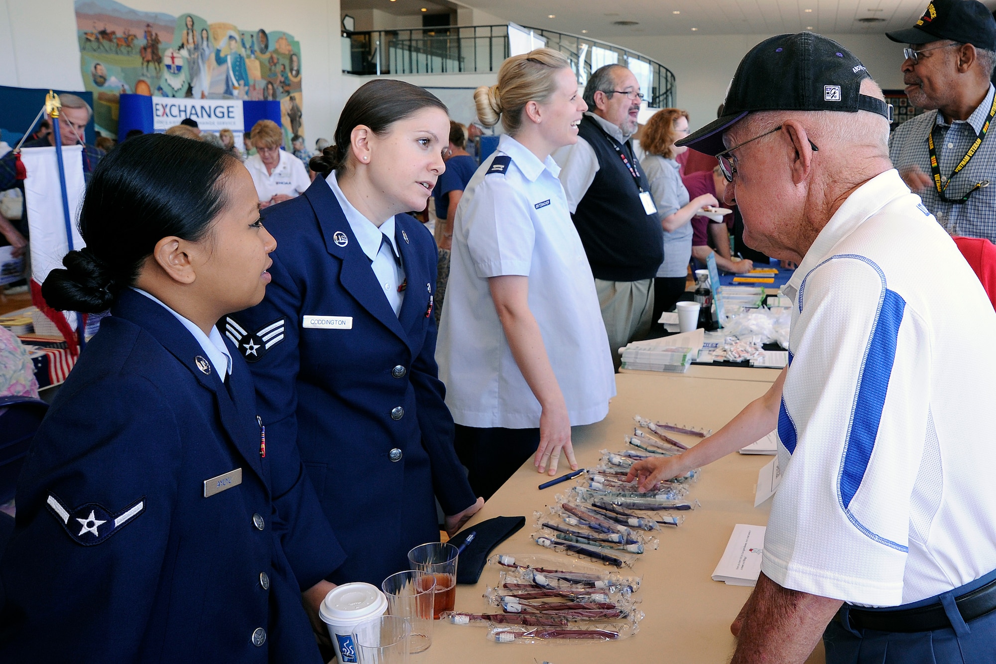 Airman Holly Ayuyu and Senior Airman Barbara Coddington speak with a visitor during the Front Range Retiree Appreciation Day at the Air Force Academy July 23, 2011. Ayuyu and Coddington are dental technicians with the Academy's 10th Dental Squadron. (U.S. Air Force photo/Mike Kaplan)