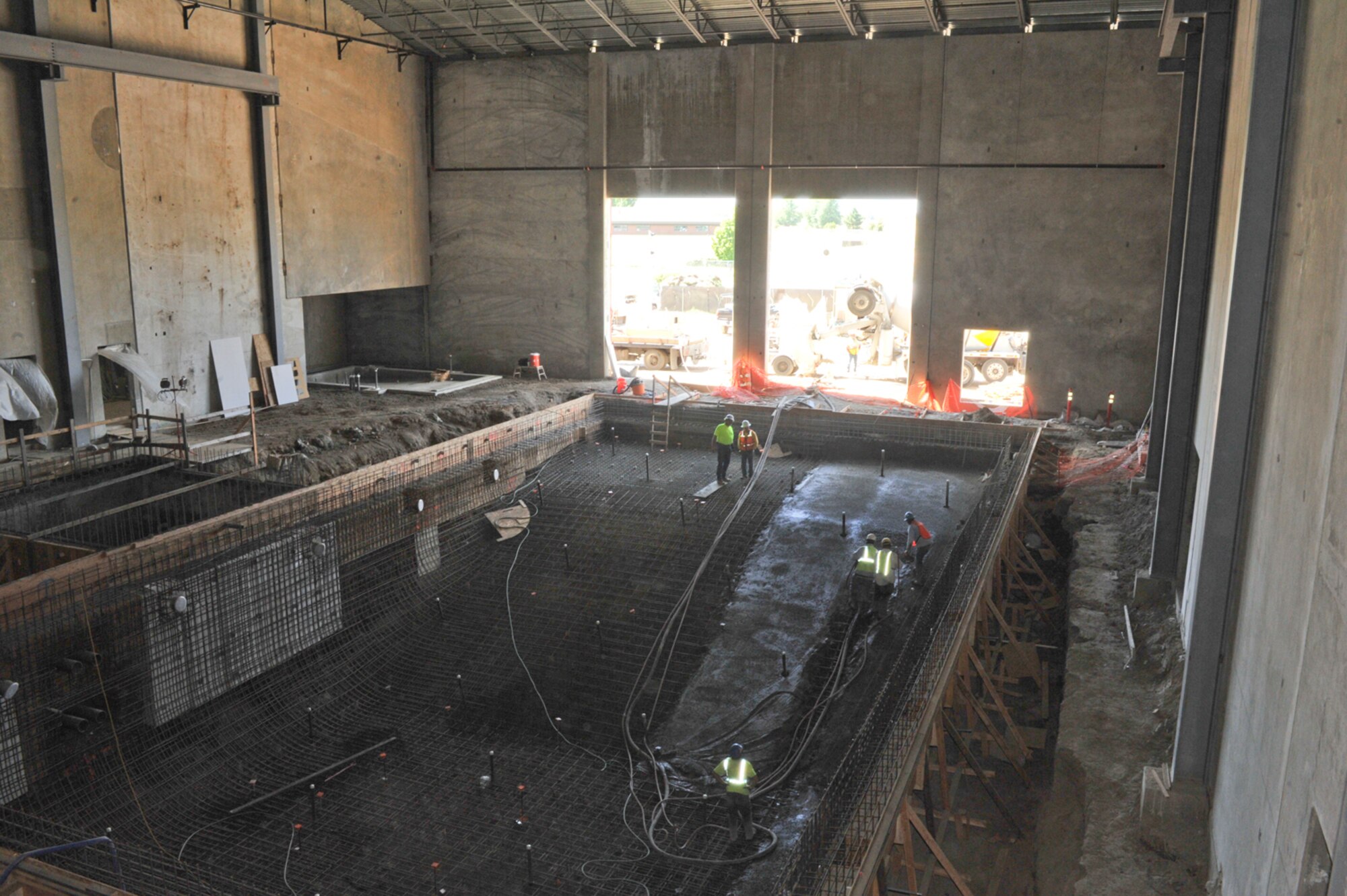 Lydig construction workers pour shock concrete in the new Fairchild Fitness Center swimming pool July 8. The pool is slated to be 14-feet deep and more user-friendly for patrons. (U.S. Air Force photo/Tech. Sgt. JT May III)