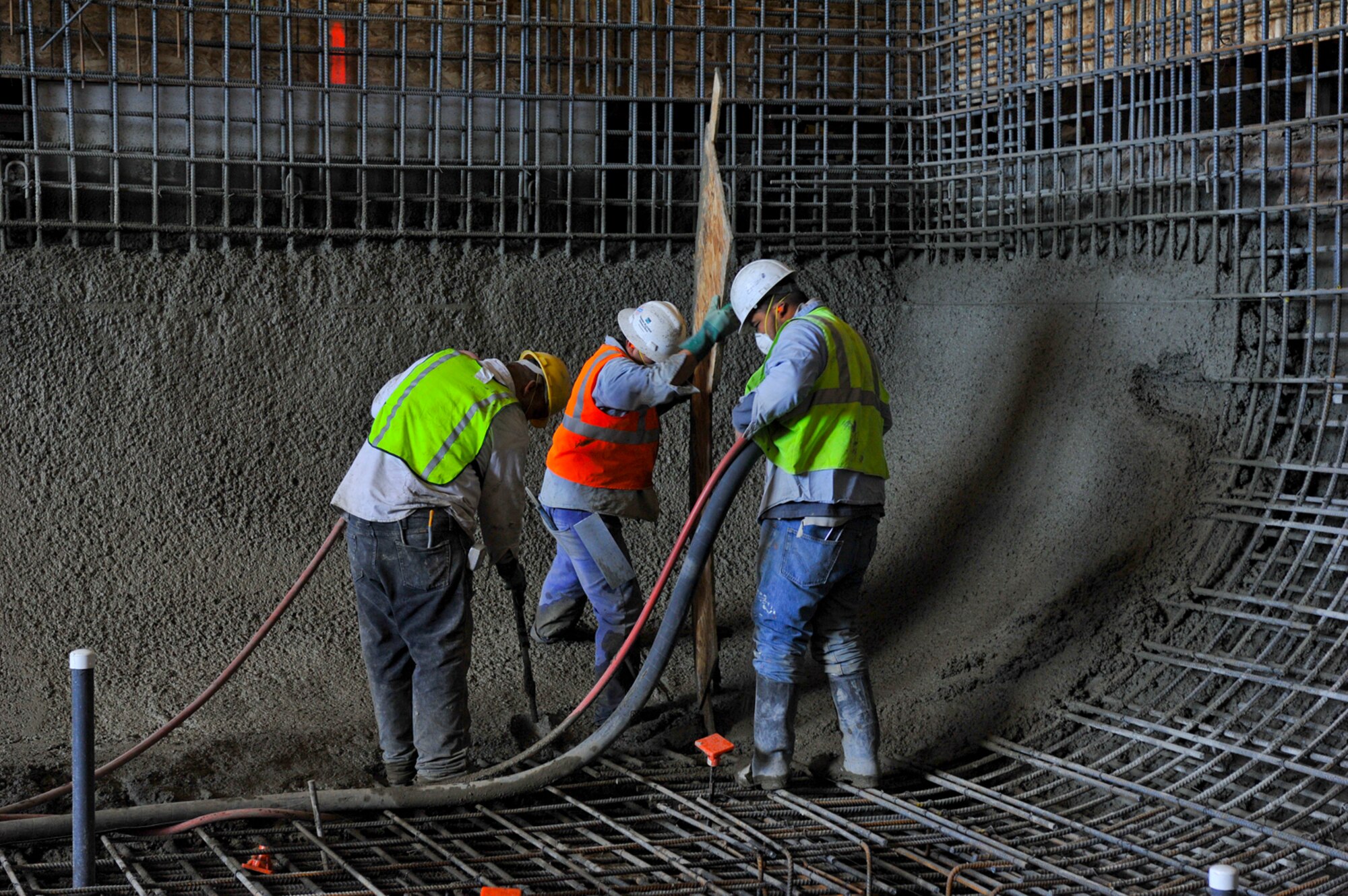 Lydig construction workers pour shock concrete in the new Fairchild Fitness Center swimming pool July 8. The pool is slated to be 14-feet deep and more user-friendly for patrons. (U.S. Air Force photo/Tech. Sgt. JT May III)