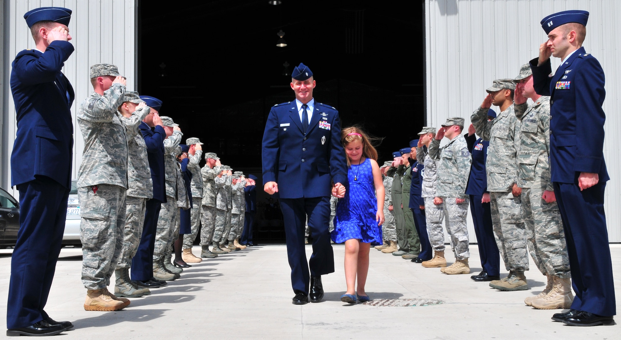 Lt. Col. Mike Assid and his daughter leaving the change of command of the 380th Space Control Squadron at the West Pac Restorations Hangar One in Colorado Springs, Colo., July 10. (U.S. Air Force photo by Tech. Sgt. Nick Ontiveros)