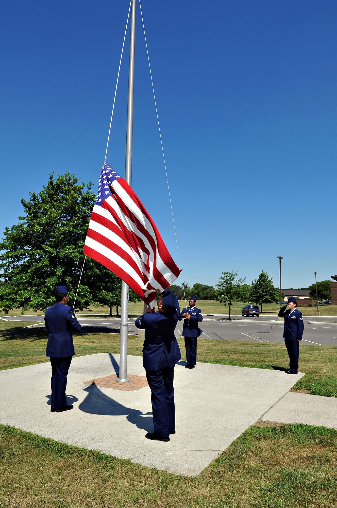 Kish Airman Leadership School graduates lower the flag during their final retreat and inspection. Squadron leadership, supervisors and family members were invited to experience the activities of the final day and the graduation ceremony. (U.S. Air Force photo by Wayne Russell/Released)