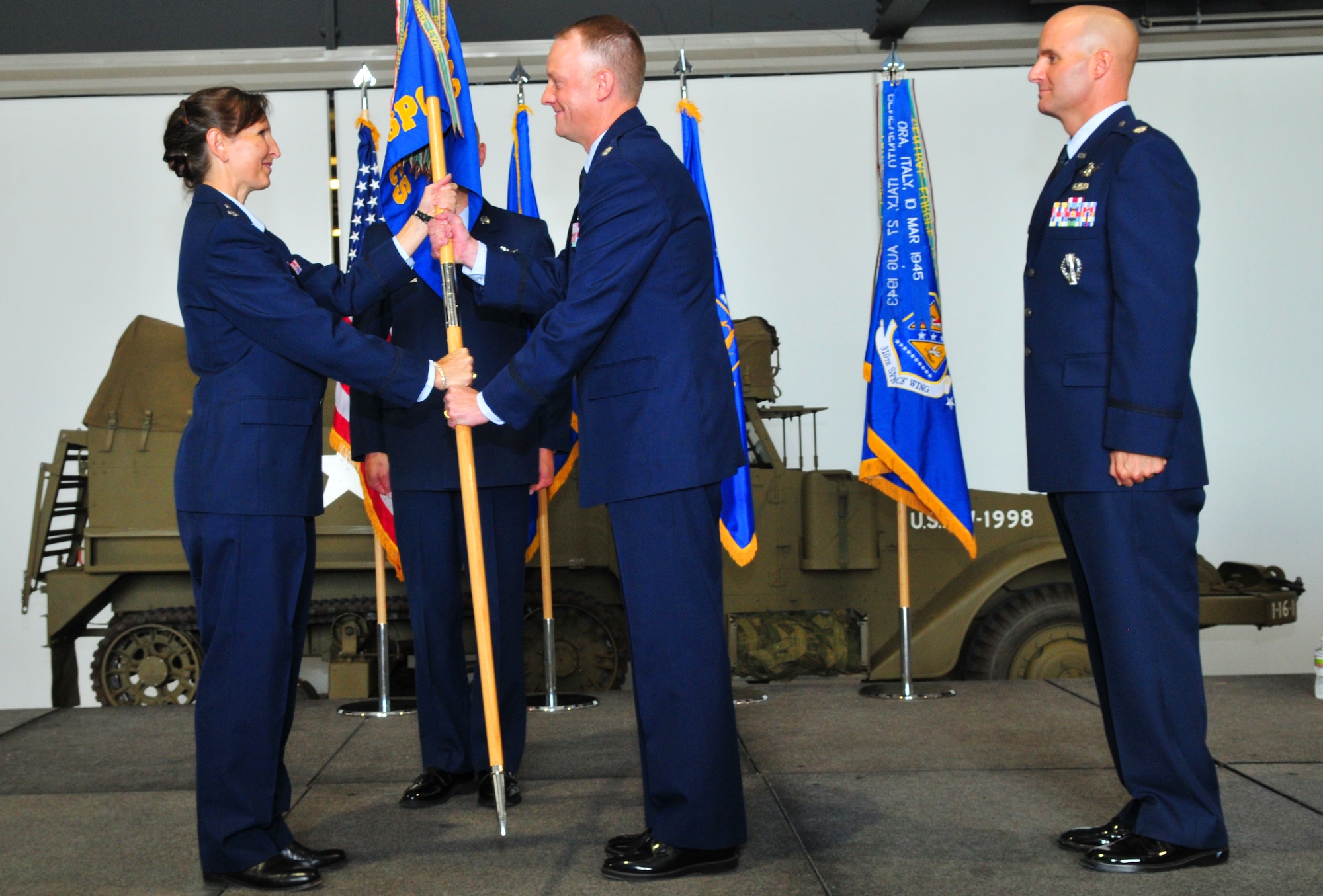 Lt. Col. Robert Claude accepts command of the 380th Space Control Squadron from Lt. Col. Traci Kueker-Murpy, commander of the 310th Operations Group, at the West Pac Restorations Hangar One in Colorado Springs, Colo., July 10. (U.S. Air Force photo by Tech. Sgt. Nick Ontiveros)