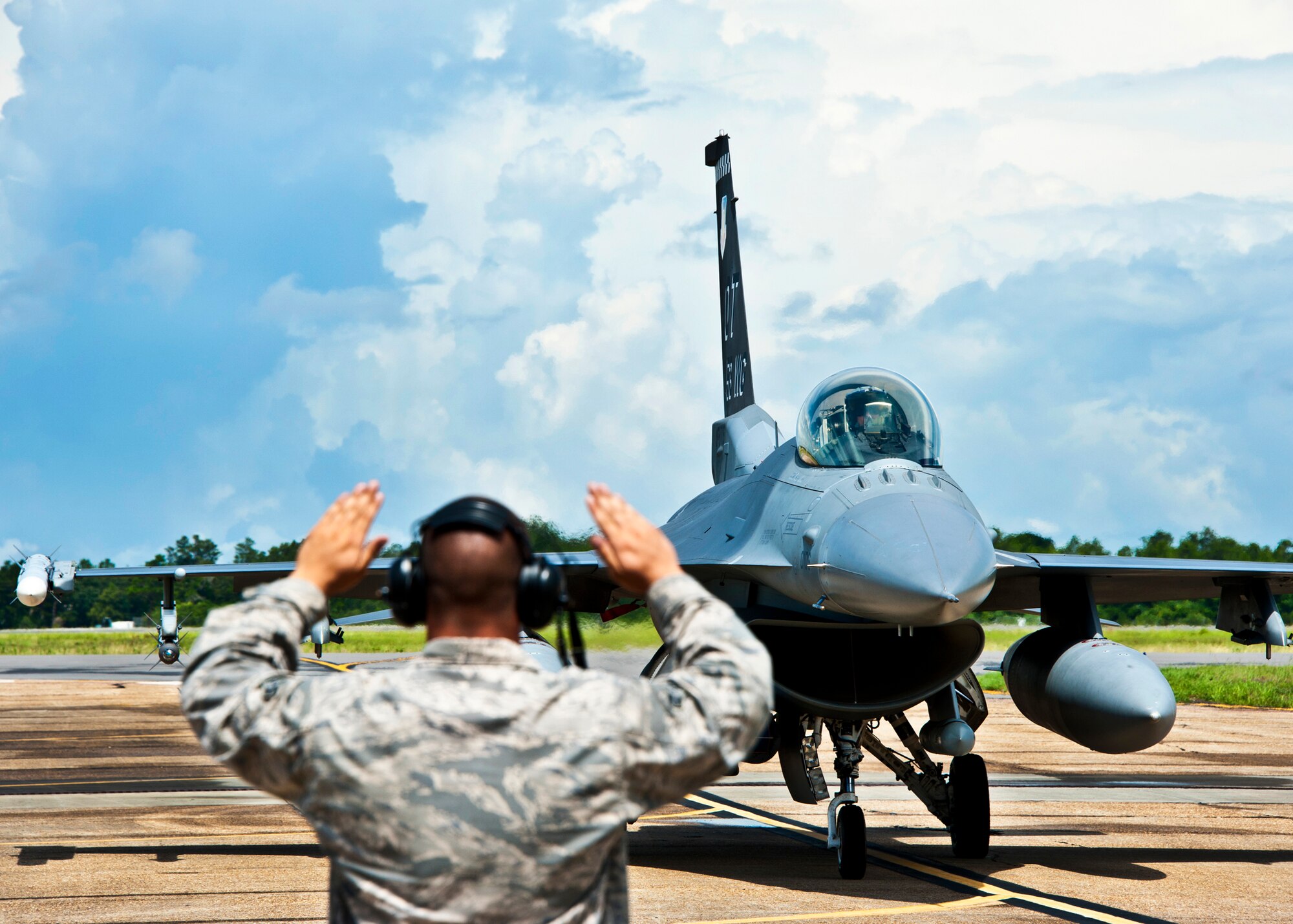 Airman 1st Class Josh Mouser, of the 46th Aircraft Maintenance Squadron, marshals in Col. Michael Gantt, commander of the 53rd Wing, after his final flight July 22 at Eglin Air Force Base, Fla.  Gantt leaves the wing for a position with Air Force A5 at the Pentagon.  (U.S. Air Force photo/Samuel King Jr.)