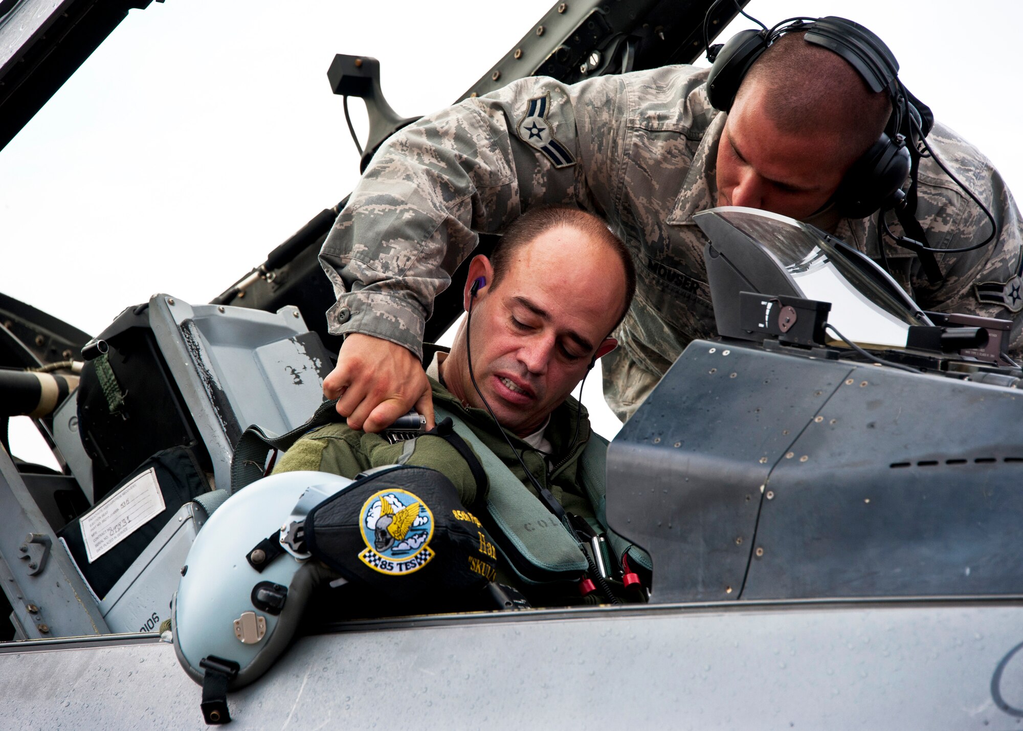 Airman 1st Class Josh Mouser, of the 46th Aircraft Maintenance Squadron, helps Col. Michael Gantt strap in for his final flight as commander of the 53rd Wing July 22 at Eglin Air Force Base, Fla.  Gantt leaves the wing for a position with Air Force A5 at the Pentagon.  (U.S. Air Force photo/Samuel King Jr.)