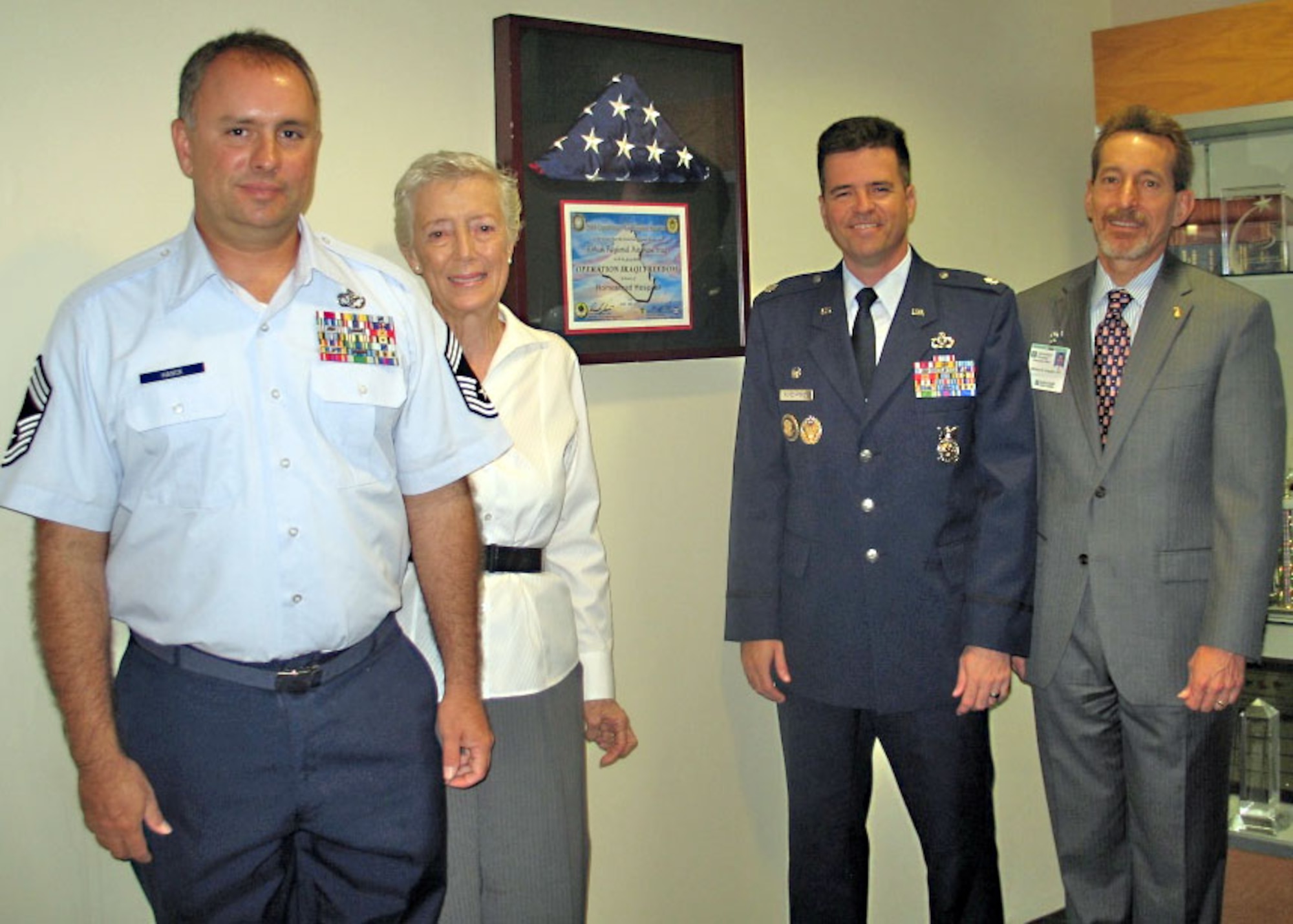 Chief Master Sgt. David Hanck, Barbara Hanck, Lt. Col. Theodore Munchmeyer and Bill Duquette, CEO of Homestead Hospital, at the dedication ceremony of the American flag flown over Kirkuk air base in Iraq in honor of the hospital.