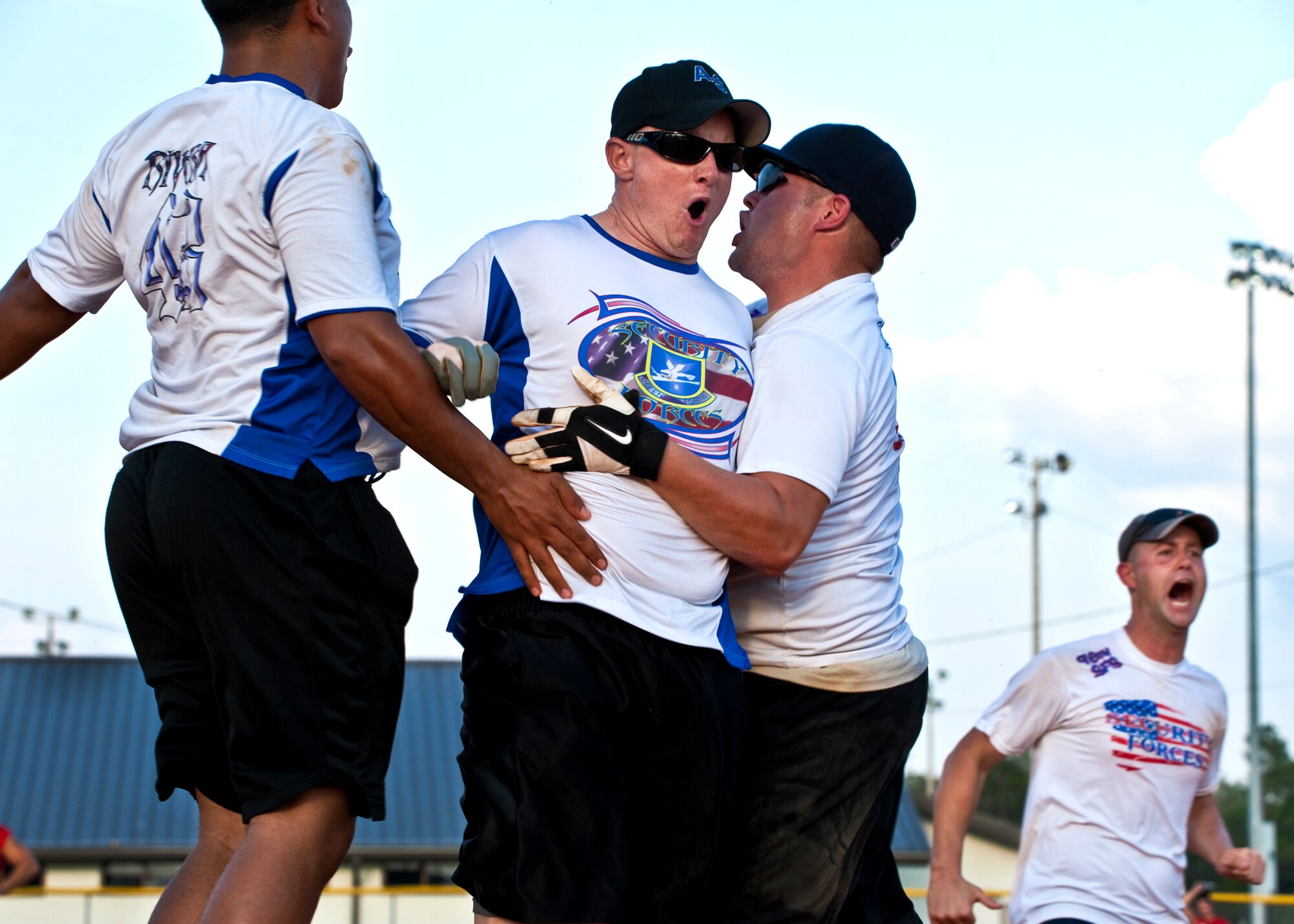 Travis Holcomb and his 96th Security Forces Squadron teammates celebrate after he crossed the plate for the winning run during their intramural softball championship game at Eglin Air Force Base, Fla., July 20.  SFS came from behind in the final inning to take the championship 16-15. (U.S. Air Force photo/Samuel King Jr.)