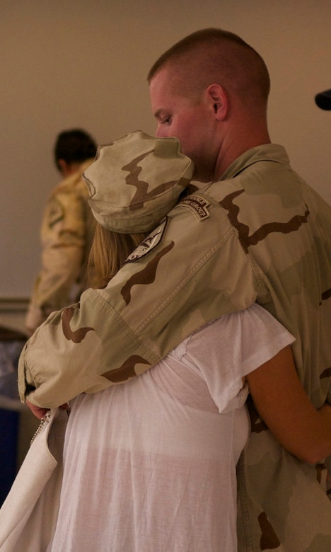 A Port Security Unit 307 member embraces his spouse before he deploys to the Middle East in support of Operation New Dawn, July 22, 2011. While deployed, PSU 307 will be charged with providing harbor defense and security to ports, seaward approaches, and waterways within U.S. Central Command's area of responsibility and ensuring the free flow of personnel, equipment and commerce in the region. (U.S. Coast Guard photo by Petty Officer 2nd Class Michael Anderson/Released)