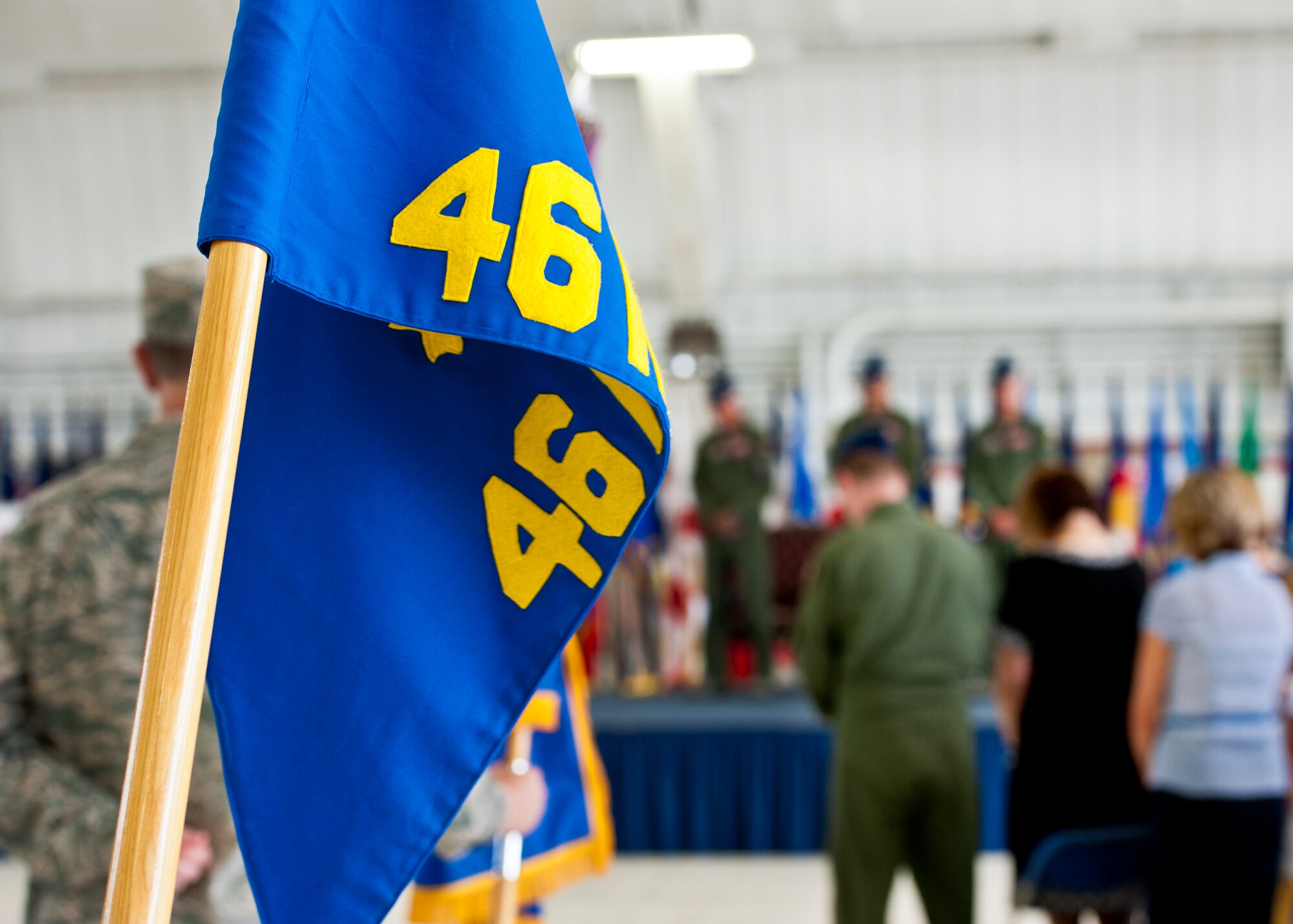 A group guidon for the 46th Test Wing stands at the ready during a quiet moment at the wing change of command ceremony July 22 at Eglin Air Force Base, Fla.  Col. Colin Miller took command of the wing from Col. Michael Brewer.   (U.S. Air Force photo/Samuel King Jr.)