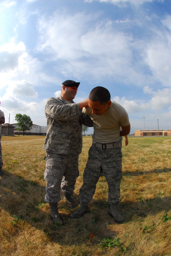 Master Sgt Marvin DiPilato, 914th Security Forces training manager instructs security forces augmentees on handcuffing techniques during the 914th Airlift Wing Unit Training Assembly July 22, 2011 Niagara Falls Air Reserve Station NY. The augmentees assist Military Law Enforcement with many aspects of base security. (U.S. Air Force photo by Staff Sgt. Andrew Caya)