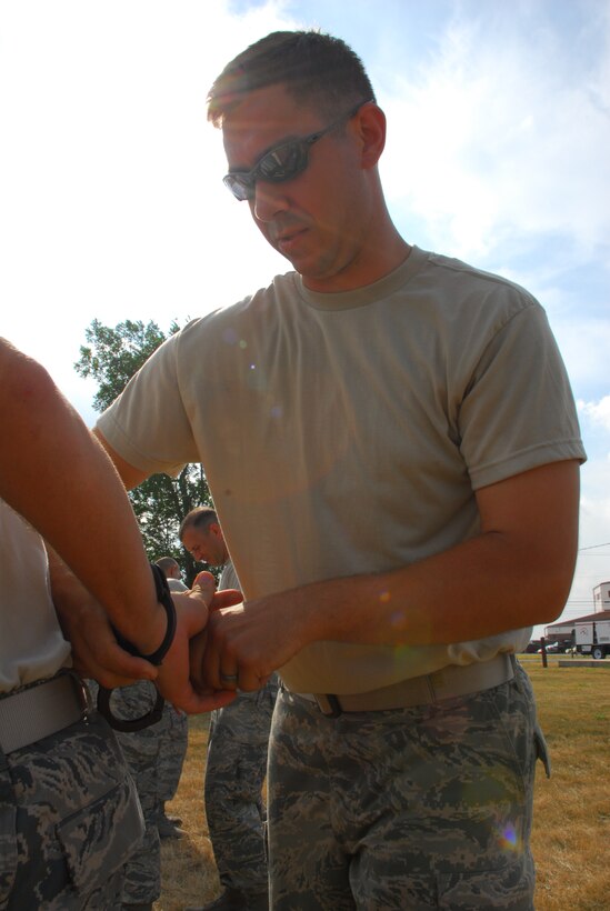 Master Sgt Marvin DiPilato, 914th Security Forces training manager instructs security forces augmentees on handcuffing techniques during the 914th Airlift Wing Unit Training Assembly July 22, 2011 Niagara Falls Air Reserve Station NY. The augmentees assist Military Law Enforcement with many aspects of base security. (U.S. Air Force photo by Staff Sgt. Andrew Caya)