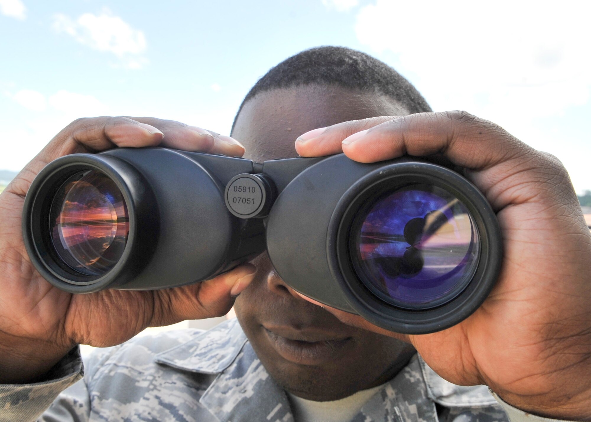 Tech. Sgt. Douglas Gaddis, 51st Operation Support Squadron air traffic controller supervisor, looks through a pair of binoculars as an aircraft approaches. The binoculars are used to ensure that the pilots have deployed the landing gear. (U.S. Air Force Photos by/ Senior Airman Adam Grant)