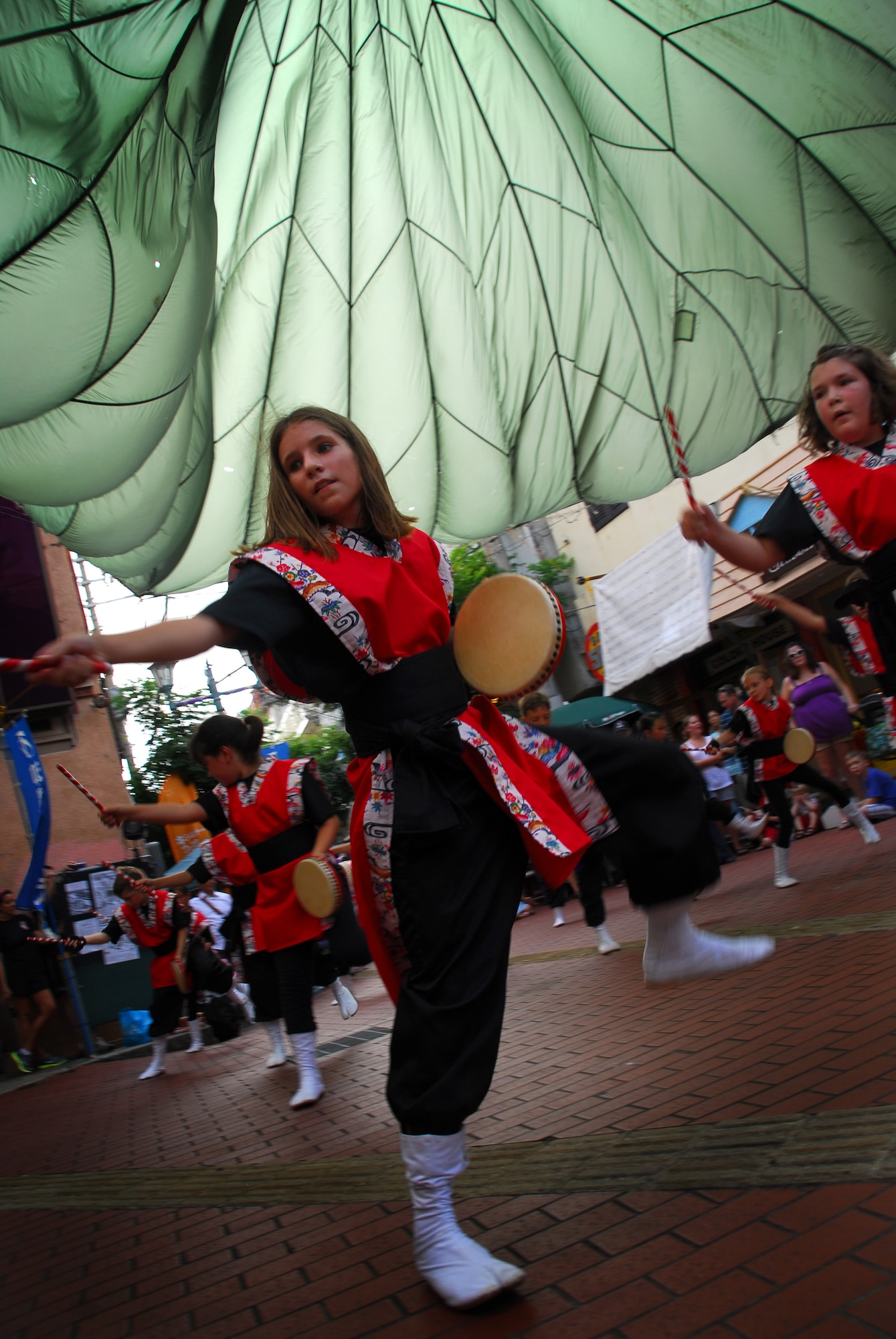 Students from Amelia Earhart Intermediate School on Kadena Air Base, Japan, perform Eisa dancing and Taiko drumming to locals, military members and their families in Okinawa City during the kick-off of the Kijimuna Festival on July 23, 2011. This annual, nine-day celebration is designed to showcase performing arts, workshops and other activities to youth. This year's event consists of performing arts companies from 14 countries and is the first time that American children have performed traditional Okinawan dance in this forum. (U.S. Air Force Photo by Tech. Sgt. Jocelyn Rich)