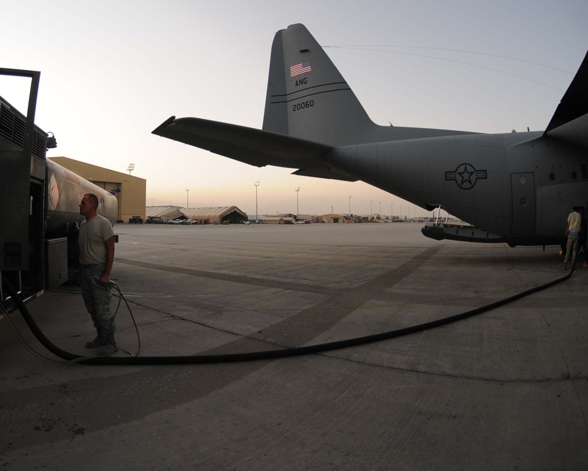 BAGRAM AIRFIELD, Afghanistan -- Airman 1st Class Johnson Barnett, 455th Expeditionary Logistics Readiness Squadron, fuels distribution operator, fuels a C-130 Hercules aircraft July 13. Airman Barnett, who hails from Ewing, Ky., refuels more than 25 aircraft per day in support of Operation Enduring Freedom.  (U.S. Air Force photo by Senior Airman Krista Rose)