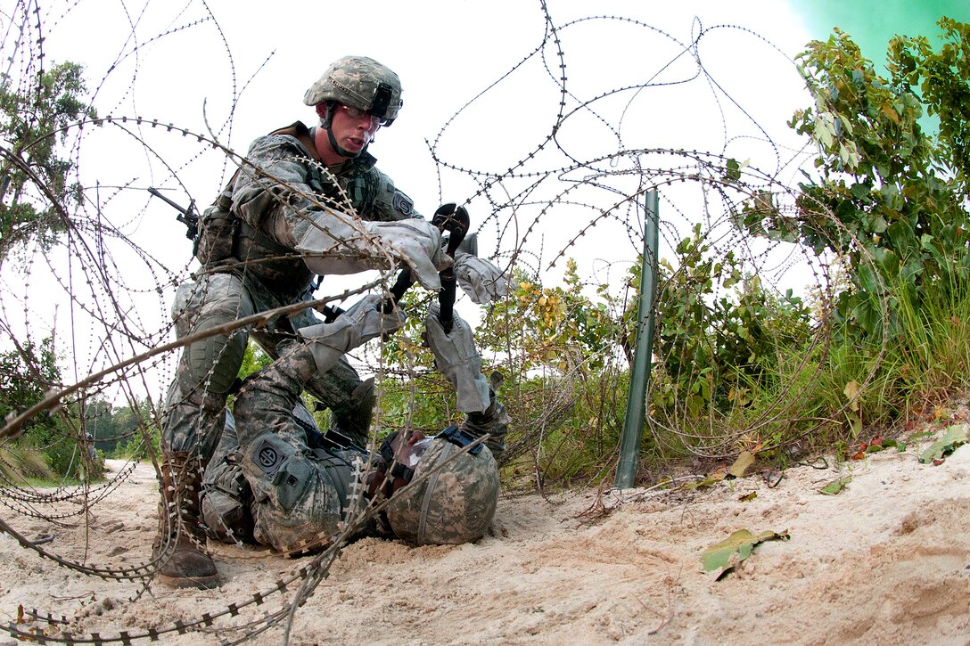 Army combat engineers cut through a wire obstacle during a live-fire training exercise on Fort Bragg, N.C., July 21, 2011. In spite of the 105-degree heat, the combat engineer paratroopers trained throughout the day and into the night.