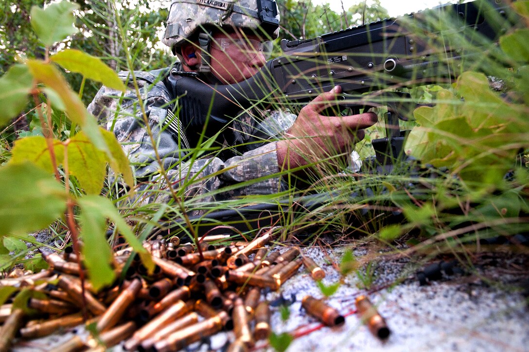 Spent shell casings pile up next to a Army combat engineer who is manning an M240-B machine gun during a live-fire exercise on Fort Bragg, N.C., July 21, 2011. Machine gunners provided covering fire while other engineers breached a wire obstacle nearby.