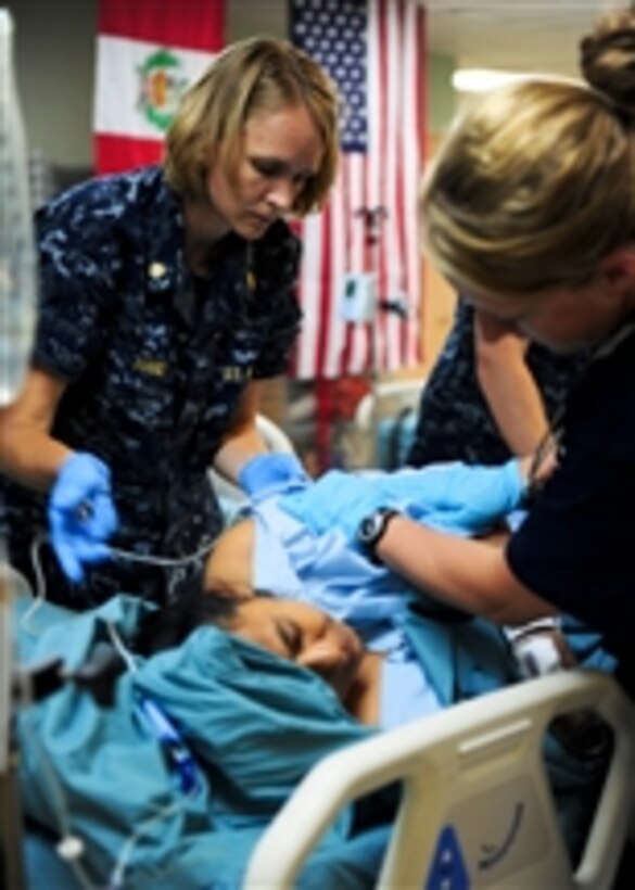 U.S. Navy Lt. Cmdr. Marsha Hanly (left) makes a patient comfortable in the intensive care unit aboard the hospital ship USNS Comfort (T-AH 20) in Acajutla, El Salvador, during Continuing Promise 2011 on July 20, 2011.  Continuing Promise is a regularly scheduled mission to countries in Central and South America and the Caribbean, where the U.S. Navy and its partnering nations work with host nations and a variety of governmental and nongovernmental agencies to train in civil-military operations.  