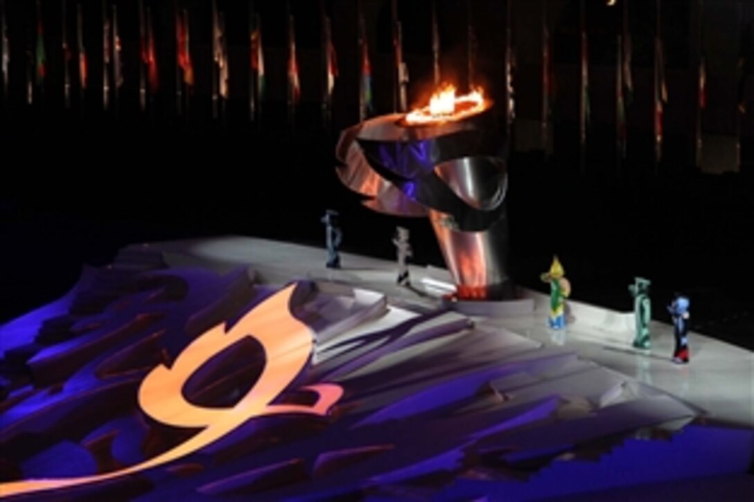 Arion, the mascot at the 5th International Military Sports Council World Games, right of the flame, salutes the troops during closing ceremonies at the Engenhao Stadium in Rio de Janeiro, July 24, 2011. Arion is flanked by the other mascots representing the armed forces. The games are aimed at fostering peace and friendship among the 7,000 troops participating. 