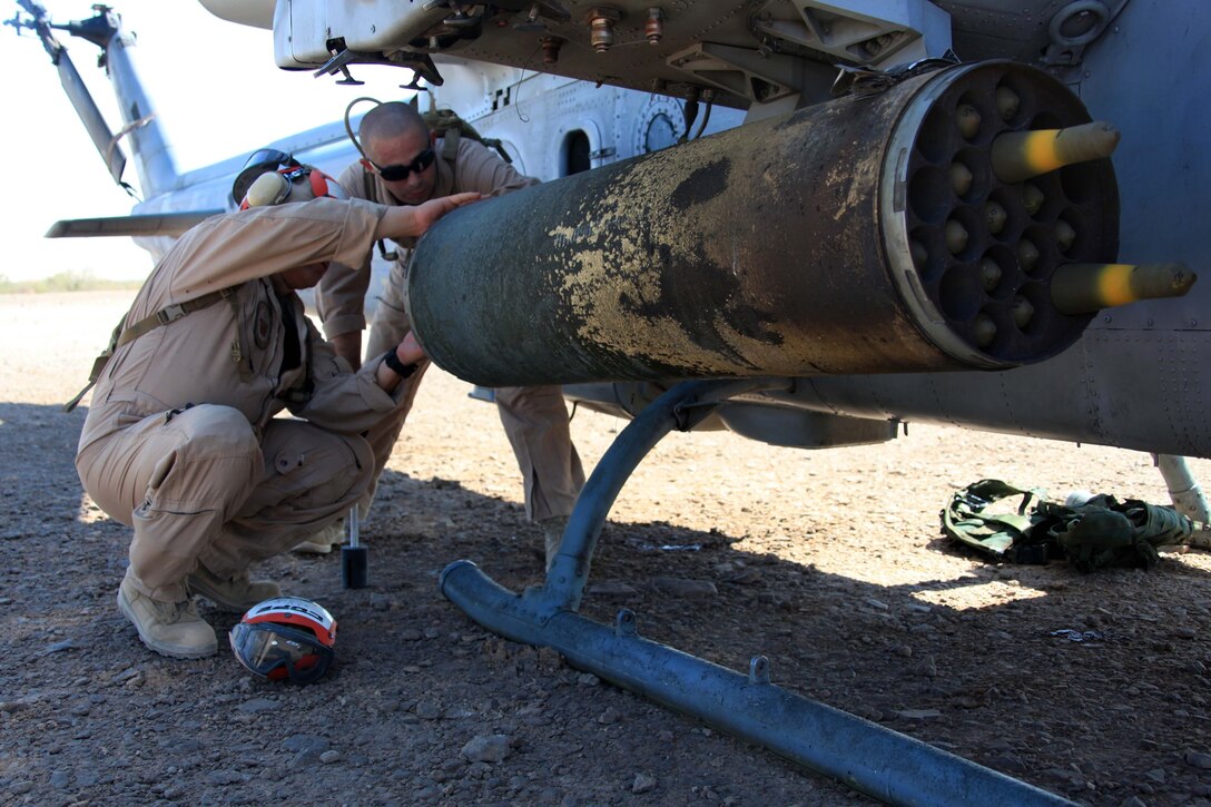 Gunnery Sgt. Angel Alvarez, Marine Aircraft Group 41 aviation ordnance chief, and Sgt. Jacob R. Copeland, MAG-49 aviation ordnance system technician, lock the 2.75 mm rockets into the external wing rocket system of a Bell AH-1 Super Cobra outside Marine Corps Air Station Yuma, Ariz., July 25. Ordnance Marines operated out of a forward arming and refueling point to ready aircraft for training missions during Operation Javelin Thrust 2011.