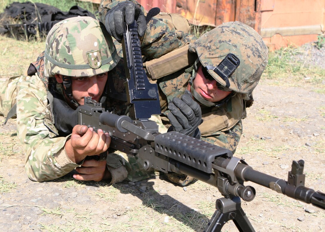 A machine gunner from Machine Gun Platoon, Support Company, Anti-Terrorism Battalion, 4th Marine Division, clears the M240B machine gun for a Georgian soldier during training here July 25 for Exercise Agile Spirit 2011.  Agile Spirit is designed to increase interoperability between Marines and the Georgian Armed Forces by exchanging and enhancing each other’s capacity in counterinsurgency and peacekeeping operations, including: small unit tactics, convoy operations, and counter-Improvised Explosive Device training.