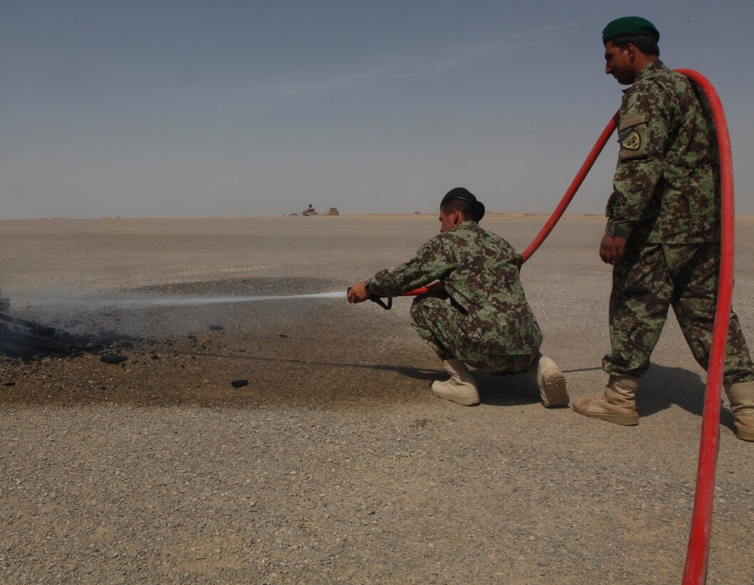 Afghan National Army firefighters extinguish a fire during a basic fire fighting course at Forward Operating Base Delaram II, Afghanistan, July 26. Aircraft rescue firefighters with Marine Wing Support Squadron 272 trained with the Afghan soldiers in the basics of firefighting techniques.