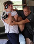 Brandon Ritter, 17, from Park Rapids, Minn., practices takedown techniques from the highcrotch position with All-Marine Wrestler Sgt. Moses Hernandez during a free-style training session at the All-Marine Wrestling Camp July 26. Ritter will be a senior at Park Rapids Area High School. For additional imagery from the event, visit www.facebook.com/rstwincities.