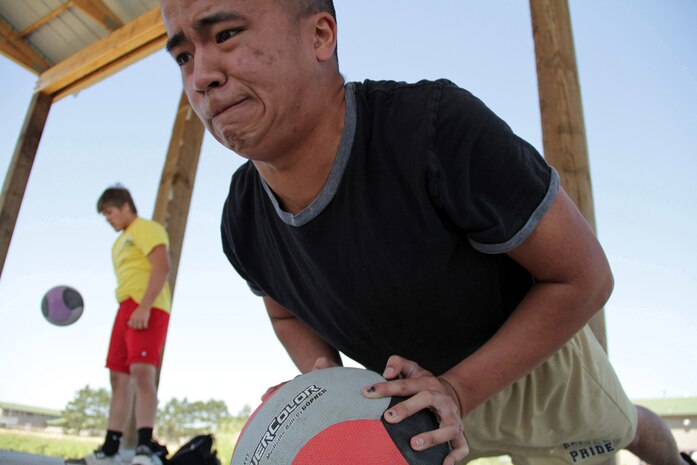 Mitchell Schenk, 16, from Harrisburg, S.D., performs medicine ball slams as Jang Xiong, 17, from Cottage Grove, Minn., knocks out one more pushup during a strength and cardio training session at the All-Marine Wrestling Camp July 26. Schenk, who placed third in the 152-pound division at the South Dakota State Tournament, will be a senior at Harrisburg High School. Xiong will be a senior at East Ridge High School. For additional imagery from the event, visit www.facebook.com/rstwincities.