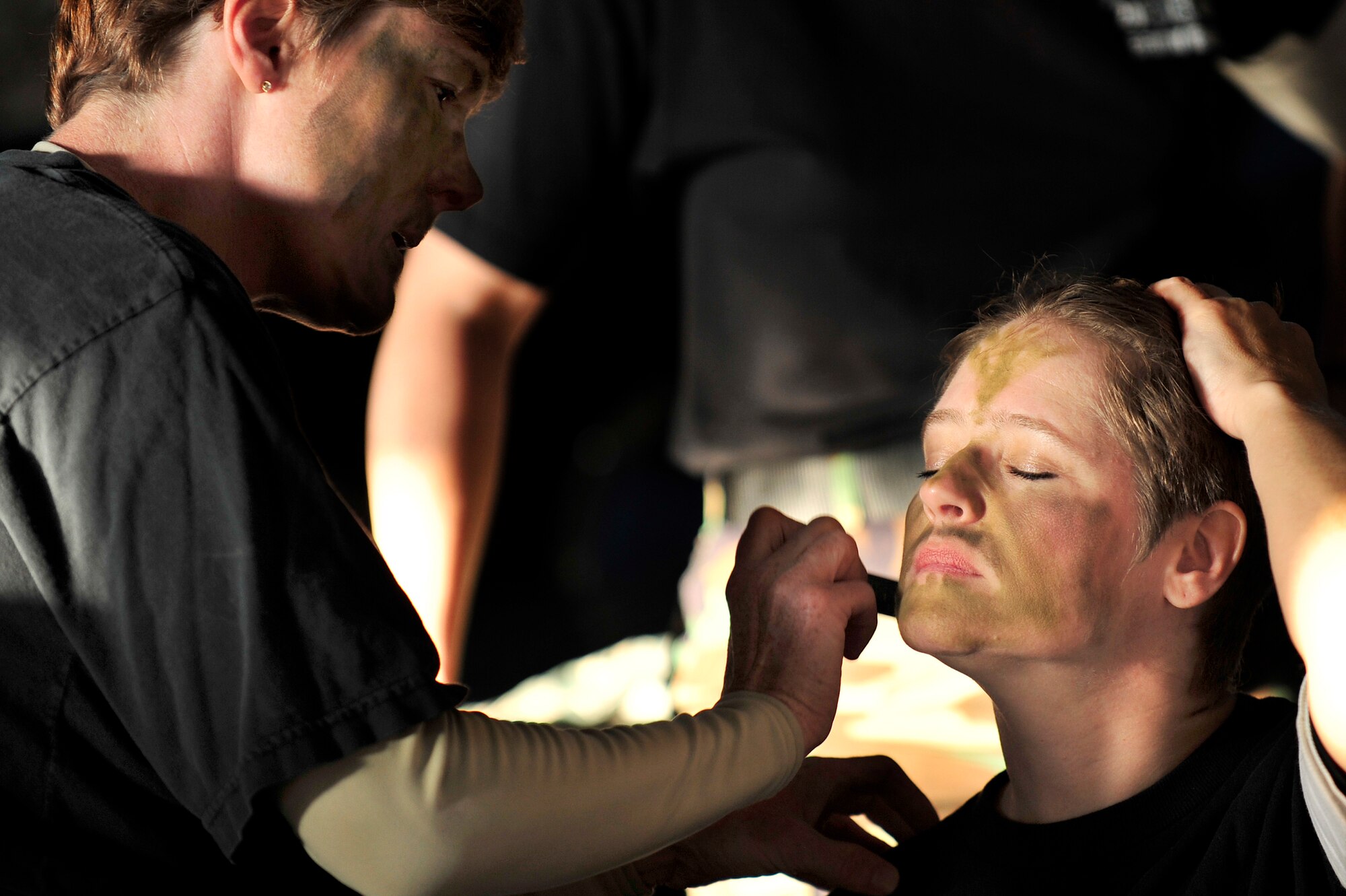 MISAWA AIR BASE, Japan -- Lt. Col. Susan Bowes, left, 35th Medical Operations Squadron, paints Maj. Marlene Wallace's, right, 35th Medical Surgical Squadron, face before the start of the 35th Fighter Wing's Dining-Out, July 22. Combat dining-outs are a formal military function that brings together units from across the base to build esprit de corps. (U.S. Air Force photo/Staff Sgt. Nathan Lipscomb/Released)