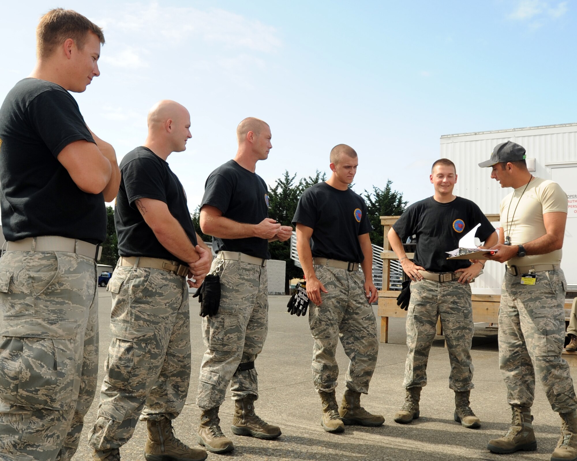 JOINT BASES LEWIS-MCCHORD, Wash. – (L to R) Senior Airman Eric Hazlewood, Staff Sgt. Eric Sims, Senior Airman William Martineau, Airman 1st Class Joshua Verran and Staff Sgt. Michael Ladrigan, 97th Logistics Readiness Squadron 2011 Air Mobility Command Rodeo team from Altus Air Force Base, Okla., listen as Rodeo Umpire, Chief Master Sgt. Samer Alkhoury debriefs them after completing the 25k Halvorson driving course July 26, 2011 during the AMC Rodeo. During the event, operators demonstrated their proficiency in maneuvering the vehicle around obstacles, followed by precisely aligning and unloading pallets in a highline dock area. (U.S. Air Force photo by Airman 1st Class Kenneth W. Norman / Released / 97th Air Mobility Wing Rodeo Public Affairs)