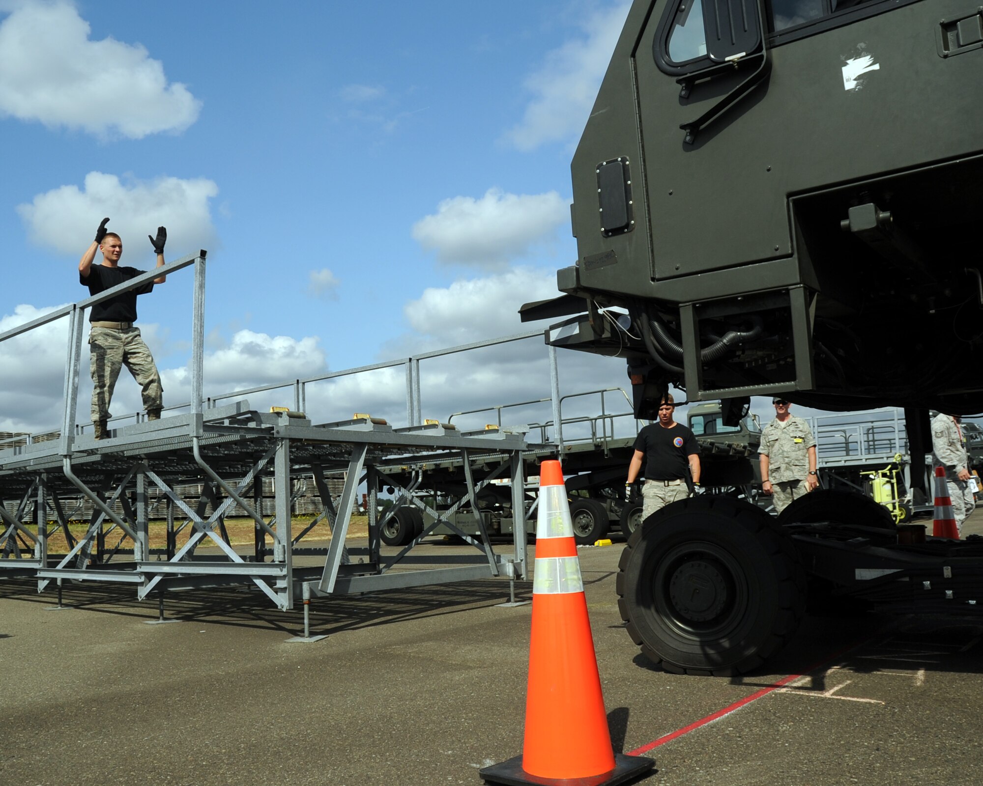 JOINT BASES LEWIS-MCCHORD, Wash. – Staff Sgt. Michael Ladrigan, 97th Logistics Readiness Squadron 2011 Air Mobility Command Rodeo team member from Altus Air Force Base, Okla., directs driver, Staff Sgt. Eric Sims as teammate Senior Airman Eric Hazlewood and a Rodeo umpire look on July 26, 2011 at the 25k Halvorson driving course during the 2011 AMC Rodeo. During the event, operators demonstrated their proficiency in maneuvering the vehicle around obstacles, followed by precisely aligning and unloading pallets in a highline dock area. (U.S. Air Force photo by Airman 1st Class Kenneth W. Norman / Released / 97th Air Mobility Wing Rodeo Public Affairs)