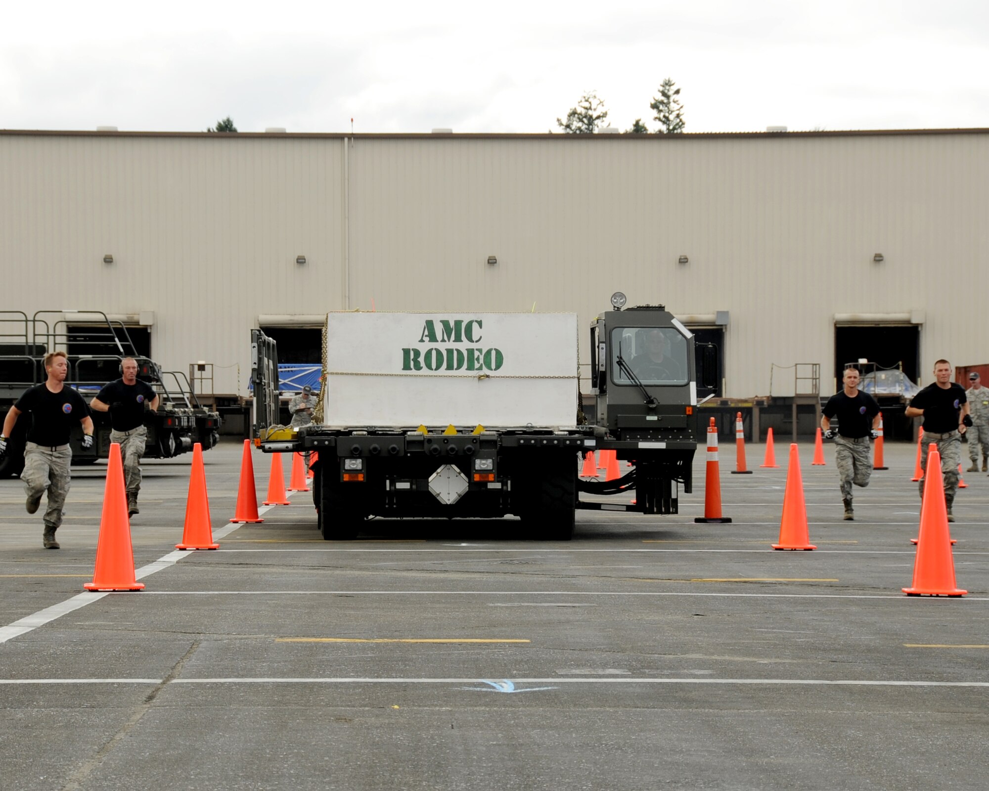 JOINT BASES LEWIS-MCCHORD, Wash. – (L to R) Senior Airmen Eric Hazlewood, William Martineau, Airman 1st Class Joshua Verran, Staff Sgt. Michael Ladrigan and driver Staff Sgt. Eric Sims, 97th Logistics Readiness Squadron 2011 Air Mobility Command Rodeo team from Altus Air Force Base, Okla., moves through the 25k Halvorson course July 26, 2011. During the event, operators demonstrated their proficiency in maneuvering the vehicle around obstacles, followed by precisely aligning and unloading pallets in a highline dock area. (U.S. Air Force photo by Airman 1st Class Kenneth W. Norman / Released / 97th Air Mobility Wing Rodeo Public Affairs)