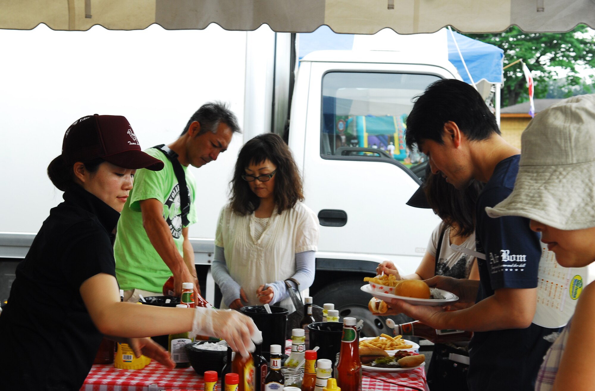 INAGI CITY, Japan - Community members from Inagi City put the finishing touches on their food during the 31st annual Inagi Festival held at Tama Hills Recreation Center, Inagi City, Japan, July 24, 2011. More than 1,800 people from Inagi City and Yokota Air Base, Japan, attended the all-day community event. (U.S. Air Force photo/Staff Sgt. Robin Stanchak)  