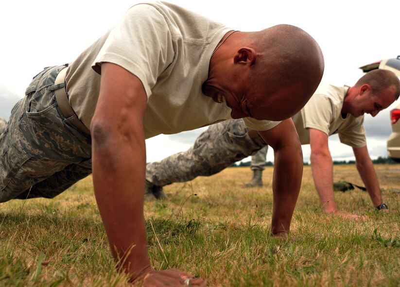 Tech. Sgt. Kurt Wells grunts through as many push-ups as he can muster during Air Mobility Rodeo 2011 July 26, 2011, at Joint Base Lewis-McChord, Wash.  Comptrollers from 11 teams Air Force-wide ran a confidence course, and were timed and tested on their memory, fitness, weapon assembly and chemical warfare skills. Wells is the NCO in charge of financial analysis with the 375th Comptroller Squadron, Scott Air Force, Ill. (U.S. Air Force photo/Senior Airman Abigail Klein)