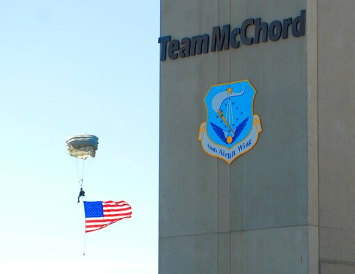 A special tactics Airman parachutes from the sky carrying an American flag during the opening ceremonies for the 2011 Air Mobility Rodeo at Joint Base Lewis-McChord, Wash., July 24. The Rodeo is a biennial, international airlift competition hosted by AMC which allows the United States and allied air forces to enjoy camaraderie while sharpening each other’s skills. (U.S. Air Force photo/Staff Sgt. Carolyn Herrick)