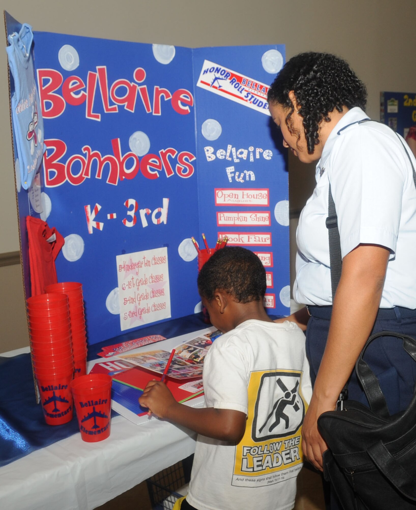 Maj. Janine Wiggins, Air Force Global Strike Command, and her son, Philip age 5, glance over a year book at the Back to School night at Hoban Hall on Barksdale Air Force Base, La., July 25. The event provided parents an opportunity to speak with school officials from the community about the different schools and the programs offered. (U.S. Air Force photo/Senior Airman Kristin High)(RELEASED)