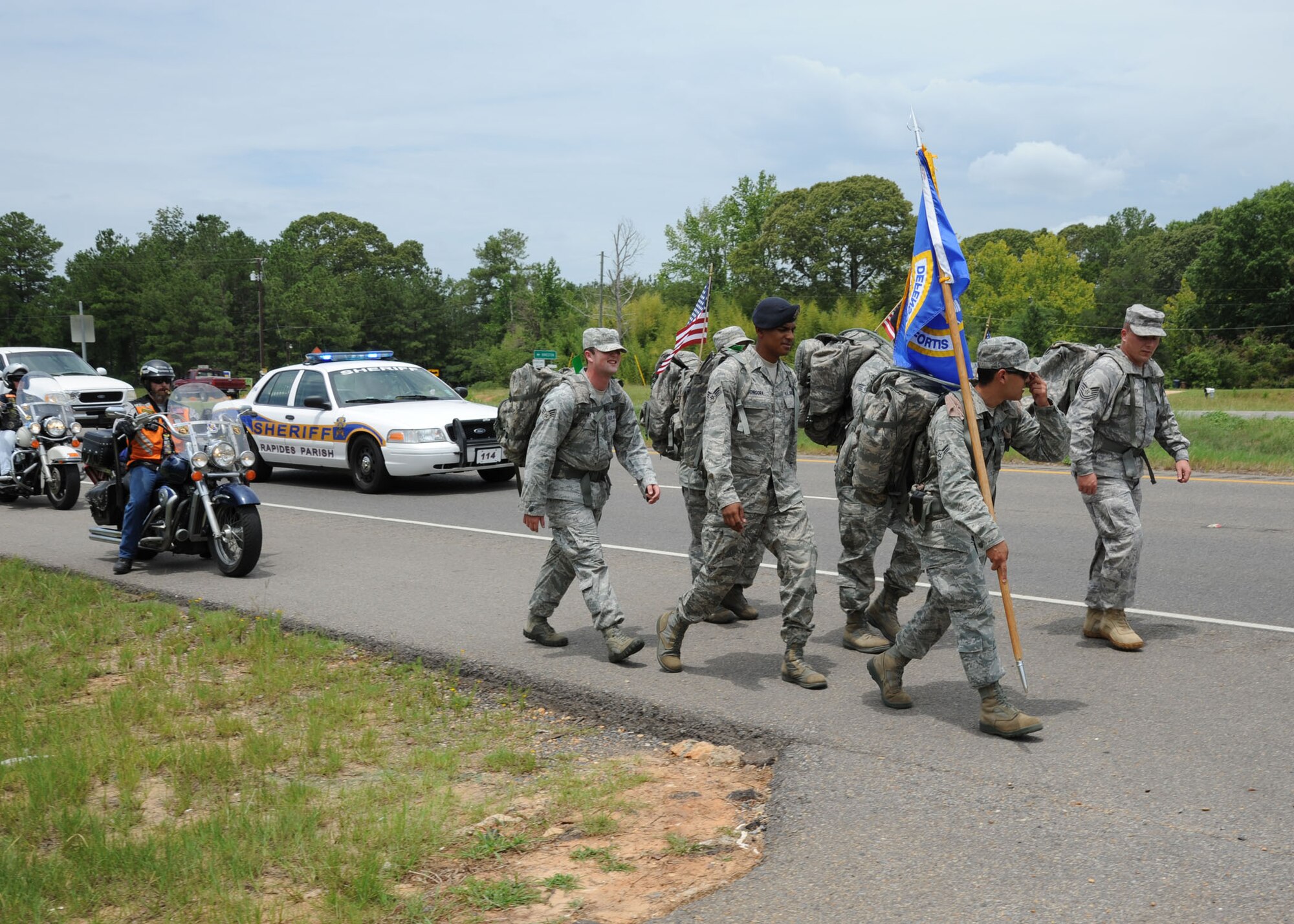 The initial escort team of the Garden Parish Police Department and the Combat Veterans Motorcycle Association trail behind members of the 14th Security Forces Squadron as they begin their 146 mile leg of the Ruck March to Remember on July 24. During their first day, the marchers were escorted by the Combat Veterans Motorcycle Association, Garden Parish Police, Alexandria Police and Pineville Police.(U.S. Air Force photo/Airman 1st Class Chase Hedrick).