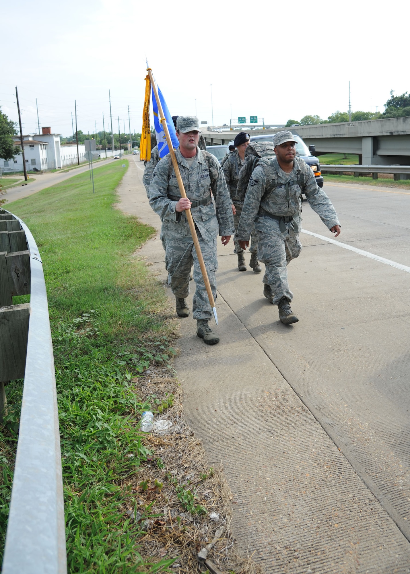 14th Security Forces members make their way up an entrance ramp to Lousianna 28 East on July 24 while being escorted by the Alexandria Police Department. Marches conquered many different types of terrain during their first day on the trek. (U.S. Air Force photo/Airman 1st Class Chase Hedrick).