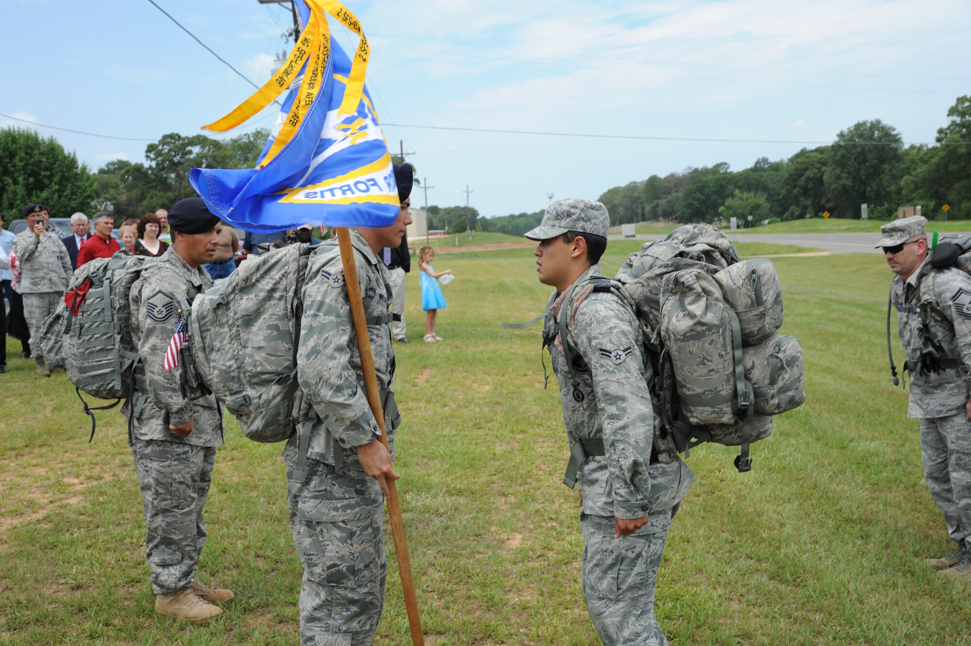 Airman 1st Class Anthony Wilson, 81st Security Forces Squadron, passes the Ruck March to Remember guidon to Airman 1st Class Christopher Herrera Ramirez, 14th Security Forces Squadron. The guidon is emblazoned with the Air Force security forces beret flash with the motto "Defensor Fortis" meaning "Defenders of the force." (U.S. Air Force photo/Airman 1st Class Chase Hedrick).