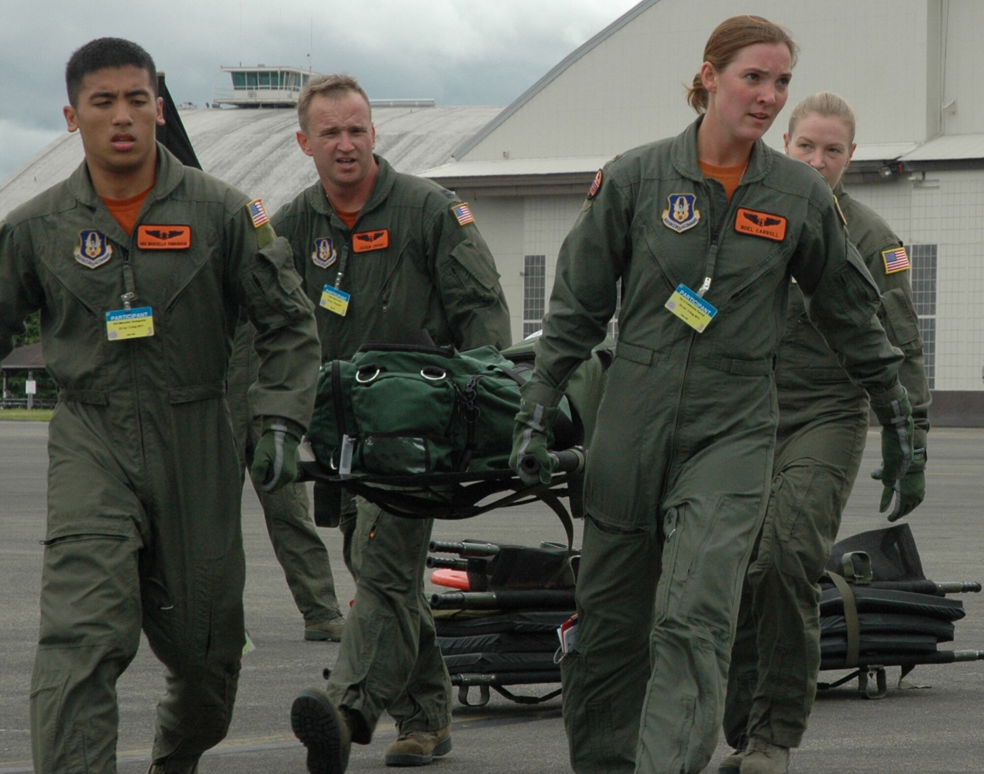 Senior Airman Marcello Yamaguchi, (clockwise) Capt. Jason Cross, Senior Airman Krystal Reinstadler and 2nd Lt. Catherine Carroll carry equipment to the Kc-135 where they are configuring the aircraft for aeromedical evacuation capability during Air Mobility Command's Rodeo July 26 at McChord Field, Wash.  This 446th Airlift Wing aeromedical evacuation team includes Senior Airman Dylan Congrove, who waits for them on the aircraft. (U.S. Air Force photo by Sandra Pishner)