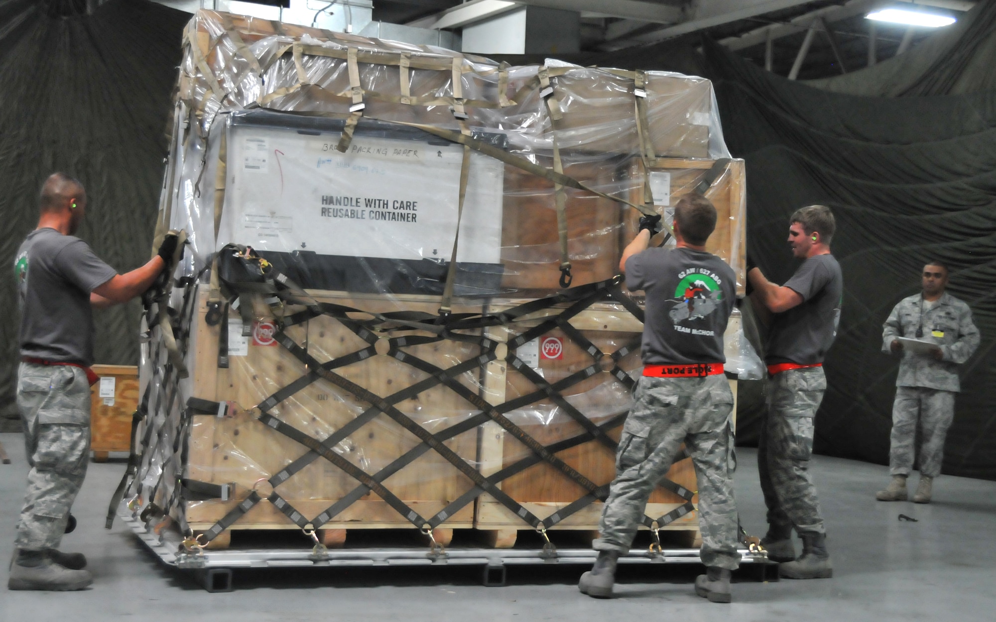 Airmen secure a pallet during a pallet build-up competition, July 25, 2011, at Joint Base Lewis-McChord, Wash. The event was part of Air Mobility Rodeo 2011, a biennial international competition that focuses on mission readiness, featuring airdrops, aerial refueling and other events that showcase the skills of mobility crews from around the world. (U.S. Air Force photo/Airman 1st Class Jared Trimarchi) 
