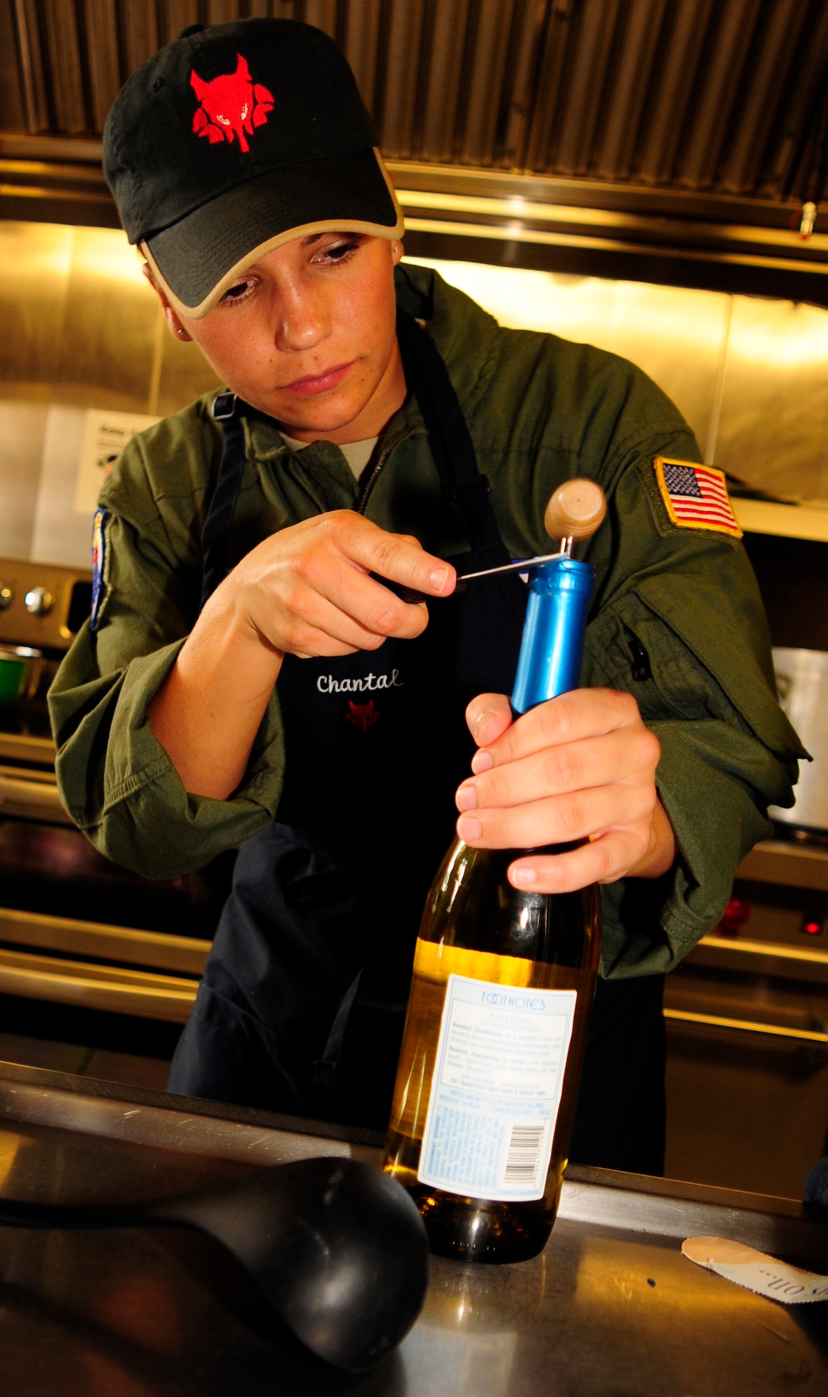 Staff Sgt. Chantal Gabaldon slices foil off a bottle of wine, July 25, 2011, as part of the first-ever Air Force flight attendant culinary competetion at Air Mobility Rodeo 2011 at Joint Base Lewis-McChord, Wash. The judges rated the meals based on taste, presentation and creativity. Five, two-person teams from around the Air Force competed in the event. Gabaldon is from the 99th Airlift Squadron, Joint Base Andrews, Md. (U.S. Air Force photo/Staff Sgt. J.G. Buzanowski)