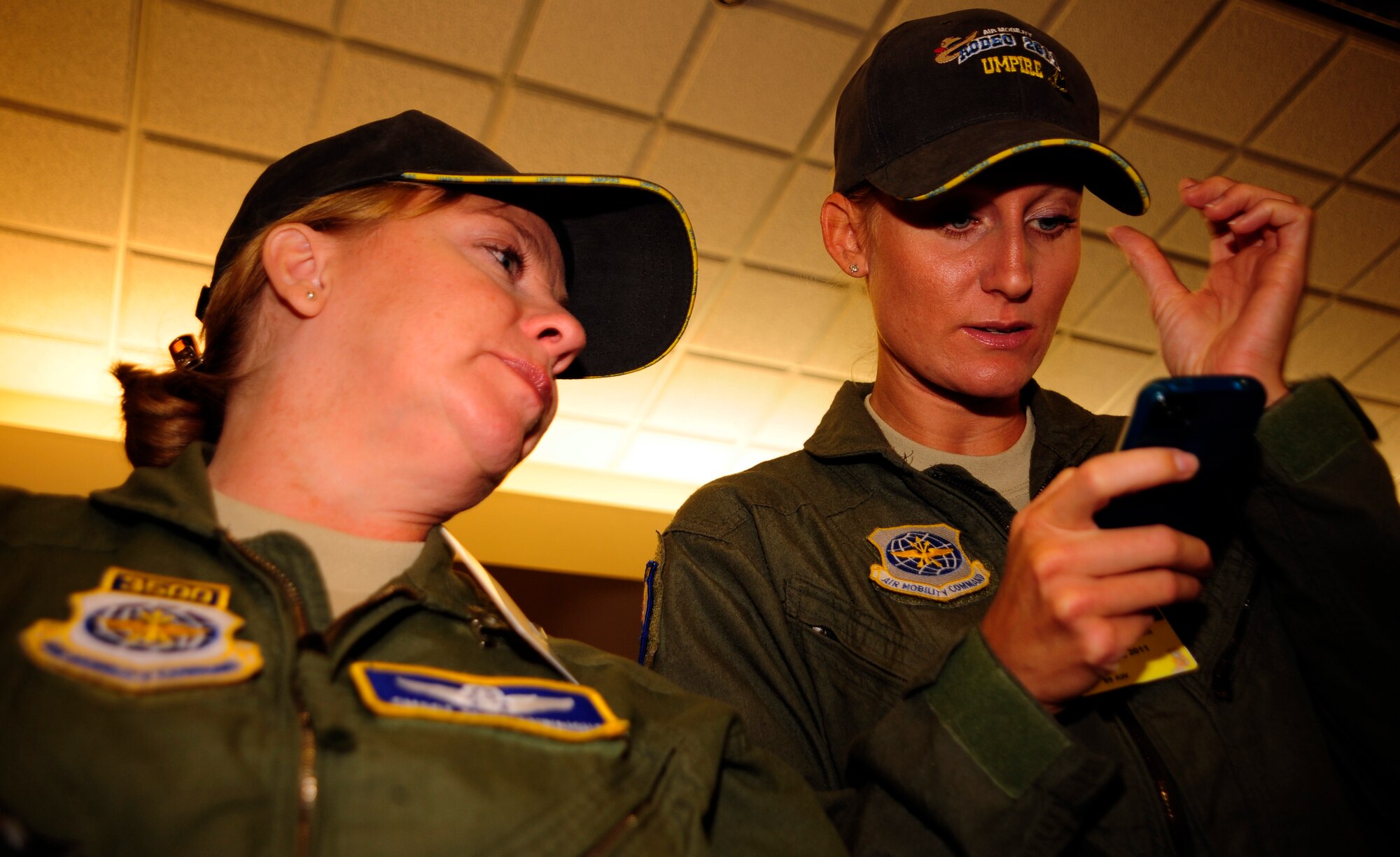 Chief Master Sgt. Seina Enwright (left) and Staff Sgt. Cat Wilkerson use a smart phone to look up specific cooking regulations, July 25, 2011, as part of the first-ever Air Force flight attendant culinary competetion at Air Mobility Rodeo 2011, Joint Base Lewis-McChord, Wash.  In addition to making sure everything was prepared safely, the judges rated the meals based on taste, presentation and creativity. Five, two-person teams from around the Air Force competed in the event. Enwright is the functional manager for flight attendants at Air Mobility Command headquarters, Scott Air Force Base, Ill.; Wilkerson is stationed at Joint Base Andrews. (U.S. Air Force photo/Staff Sgt. J.G. Buzanowski)