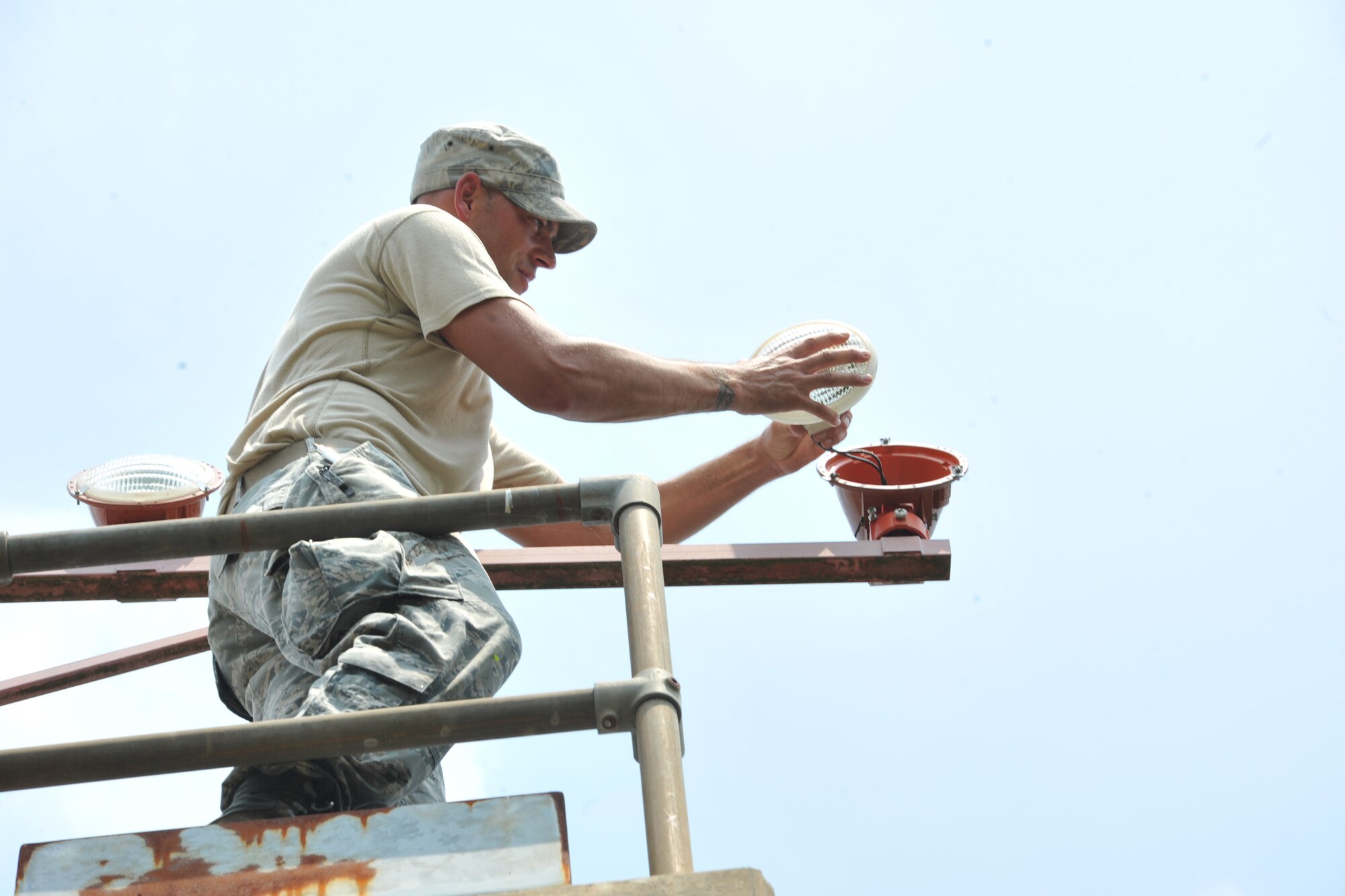 SEYMOUR JOHNSON AIR FORCE BASE, N.C.- Tech. Sgt. David Nester installs a new approach light on a west wing pillar here, July 25, 2011. Approach lights are a visual aid for pilots landing in low visibility settings. Nester is a 4th Civil Engineer Squadron electrical systems journeyman and a native of Whitmore Lake, Mich. (U.S. Air Force photo by Senior Airman Whitney Lambert/ Released)