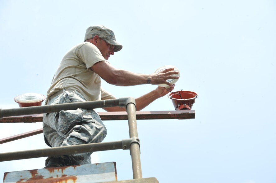 SEYMOUR JOHNSON AIR FORCE BASE, N.C.- Tech. Sgt. David Nester installs a new approach light on a west wing pillar here, July 25, 2011. Approach lights are a visual aid for pilots landing in low visibility settings. Nester is a 4th Civil Engineer Squadron electrical systems journeyman and a native of Whitmore Lake, Mich. (U.S. Air Force photo by Senior Airman Whitney Lambert/ Released)