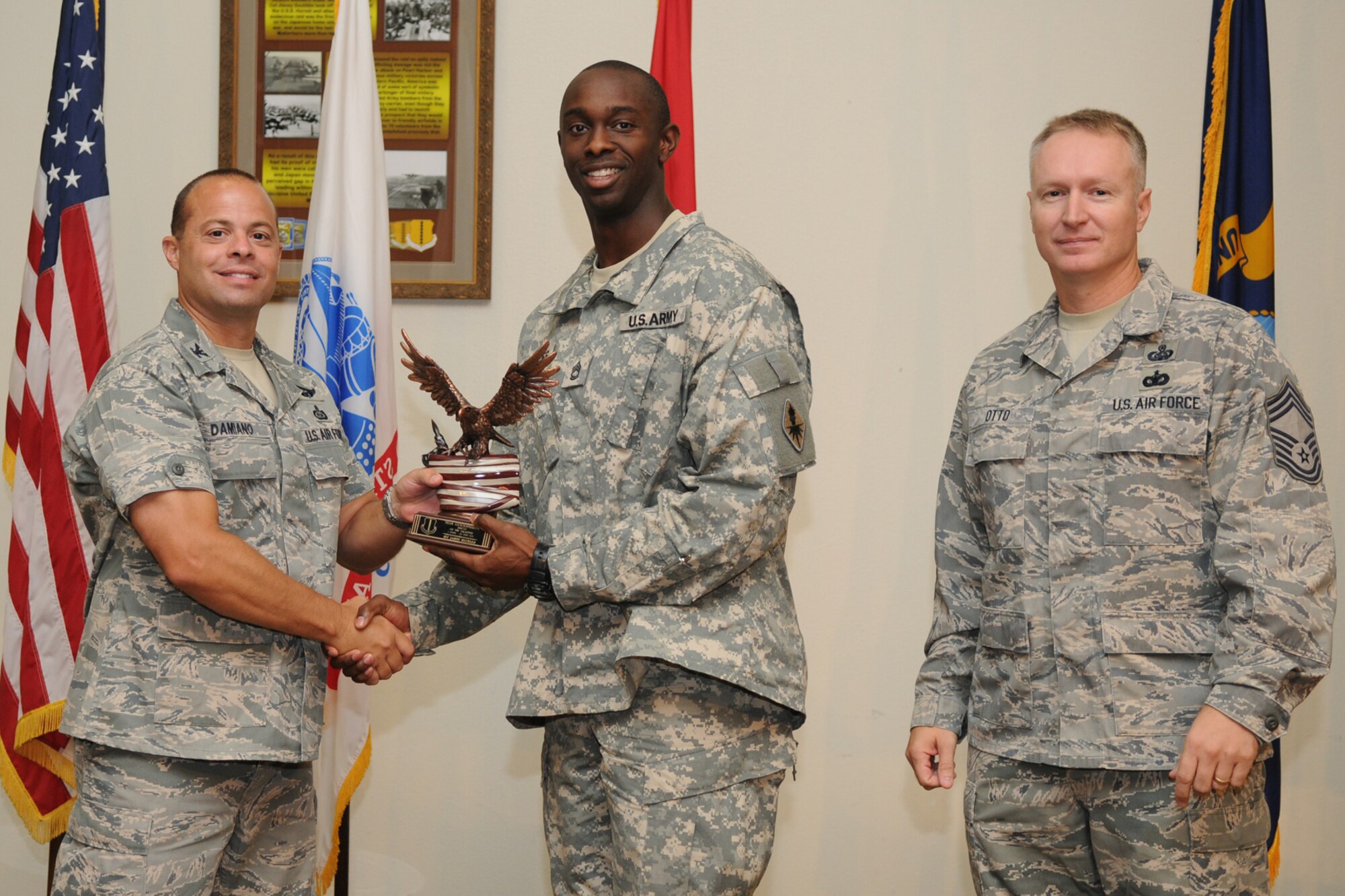 GOODFELLOW AIR FORCE BASE, Texas -- Col. Mark Damiano, 17th Training Wing Commander, and Chief Master Sgt. Quinton Otto, 17th Mission Support Group Superintendent, present the Team Goodfellow Senior NCO of the Quarter to Army Sgt. 1st Class Jason Beckles, 344th Military Intelligence Battalion, during the quarterly awards breakfast July 26 at the Event Center here.  (U.S. Air Force photo//Senior Airman Heather L. Rodgers)