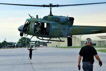 MINOT AIR FORCE BASE, N.D. -- Frantz Jean-Pierre, 54th Helicopter Squadron maintainer, guides members of the 54th HS as they land a UH-1N “Huey” helicopter onto the tarmac as part of a routine flying mission, here July 26. The mission of the 54th HS is to ensure the integrity of the 91st Missile Wing’s nuclear deterrence by providing immediate, flexible and effective combat helicopter support anywhere, anytime. (U.S. Air Force photo/ Senior Airman Jesse Lopez)