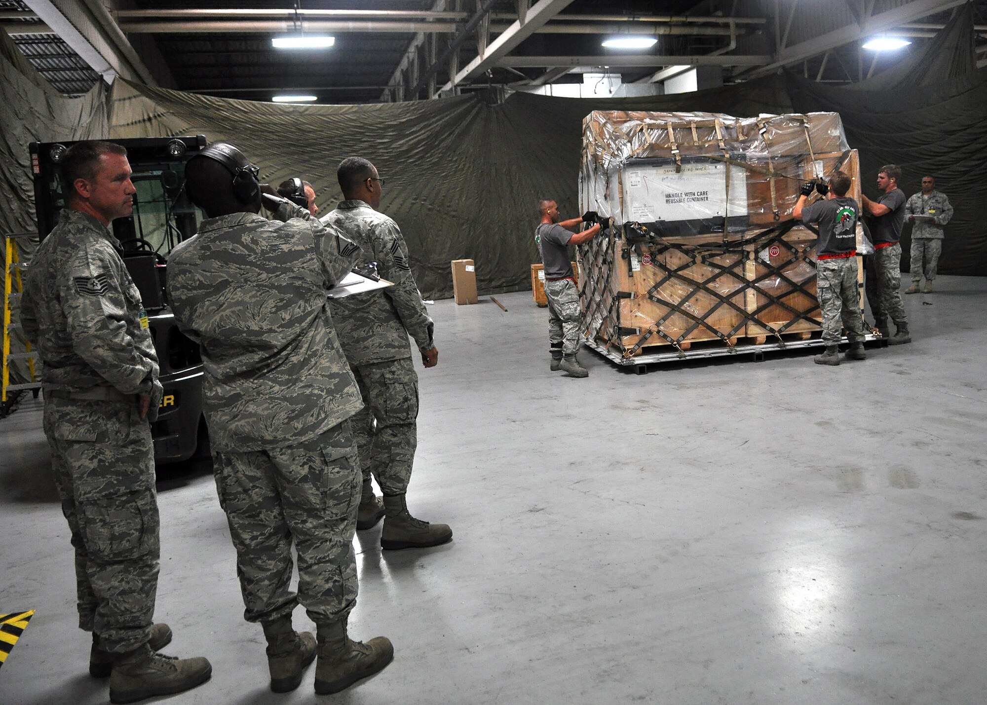 Rodeo umpires observe as the 62nd Aerial Port Rodeo team competes in a pallet buildup competition as part of Air Mobility Rodeo July 25, 2011, at Joint Base Lewis-McChord, Wash. Rodeo is a bi-annual competition that encompasses all aspects of Air Mobility Command, including aerial port, aeromedical evacuation, maintenance, security forces, and financial management. The team also competed in a 10k forklift driving course and a timed engine running on- and off-load event.  (U.S. Air Force photo/Airman 1st Class Leah Young)