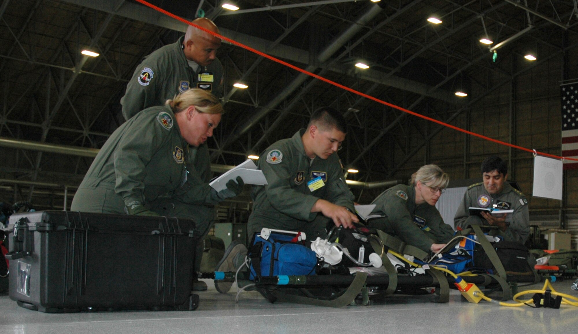 Team Pakistan's aeromedical evacuation team, supplemented by volunteers from the Reserve's 446th Aeromedical Evacuation Squadron, McChord Field, Wash., conducts a pre-flight inspection of their equipment during the Air Mobility Command's Rodeo C-17 aeromedical configuration event. Pakistan air force Capt.(Dr.) Asif Jah (right) lost his original teammates when visas did not arrive in time. A call for help went out to the aeromedical evacuation community and four volunteers from the 446th AES stepped in to complete the team. The team practiced for two days before competing July 25 at McChord Field. Helping Jah pre-flight the equipment  is (left to right) Tech. Sgt. Stephanie Wegehoft, Senior Airman Gabriel Itaya, and Master Sgt. Selina Barone.  Second Lt. Kimberley Marin is the fourth Reservist on Team Pakistan. (U.S. Air Force photo by Sandra Pishner)