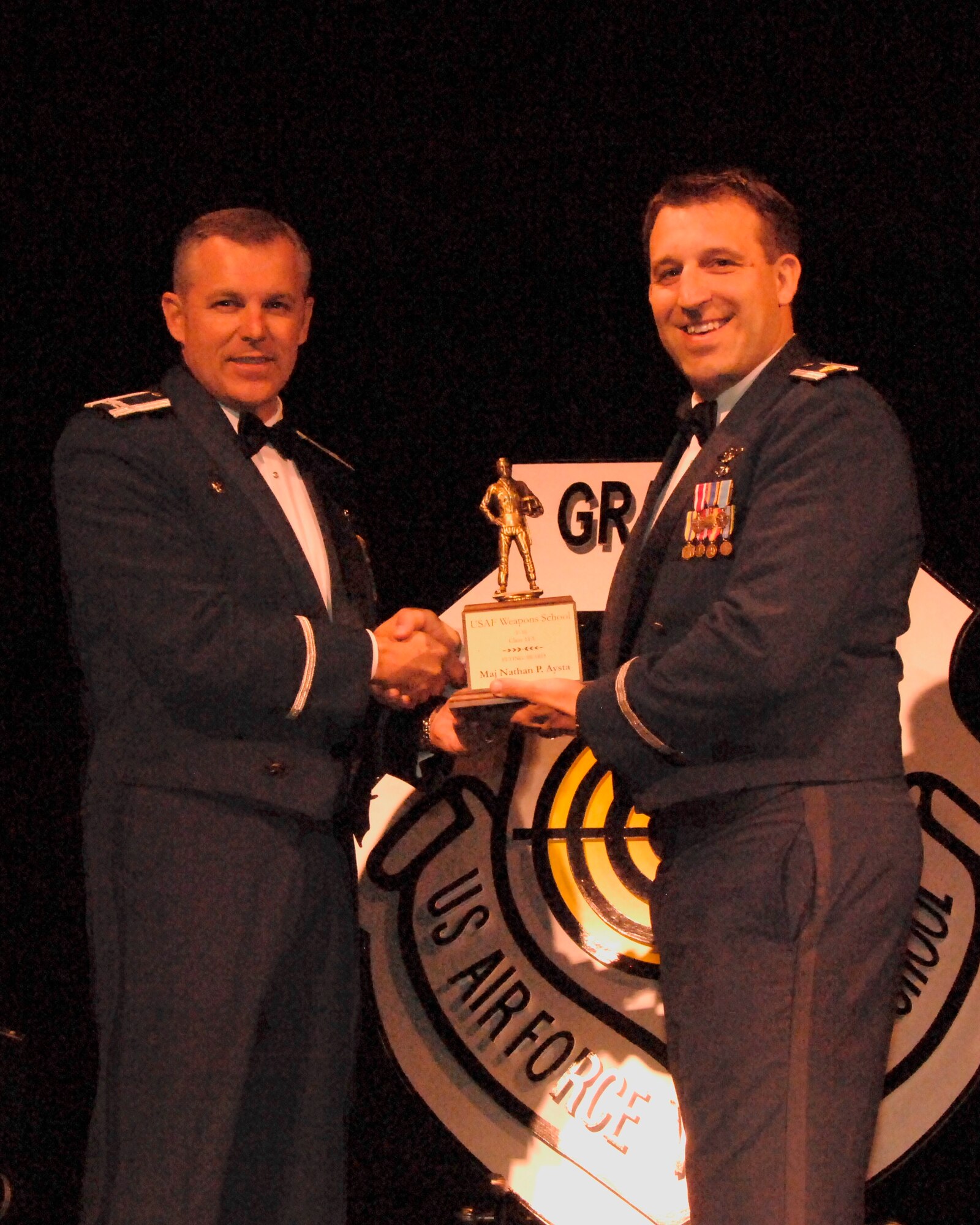 Maj. Nathan “Shaggy” Aysta is awarded the U.S. Air Force Weapons School, F-16, Class 11A “Flying Award” for demonstrating excellent instructor performance in brief, execution, and debrief throughout the course during the Weapons School graduation in Las Vegas, Nev. on Saturday, June 11, 2011.